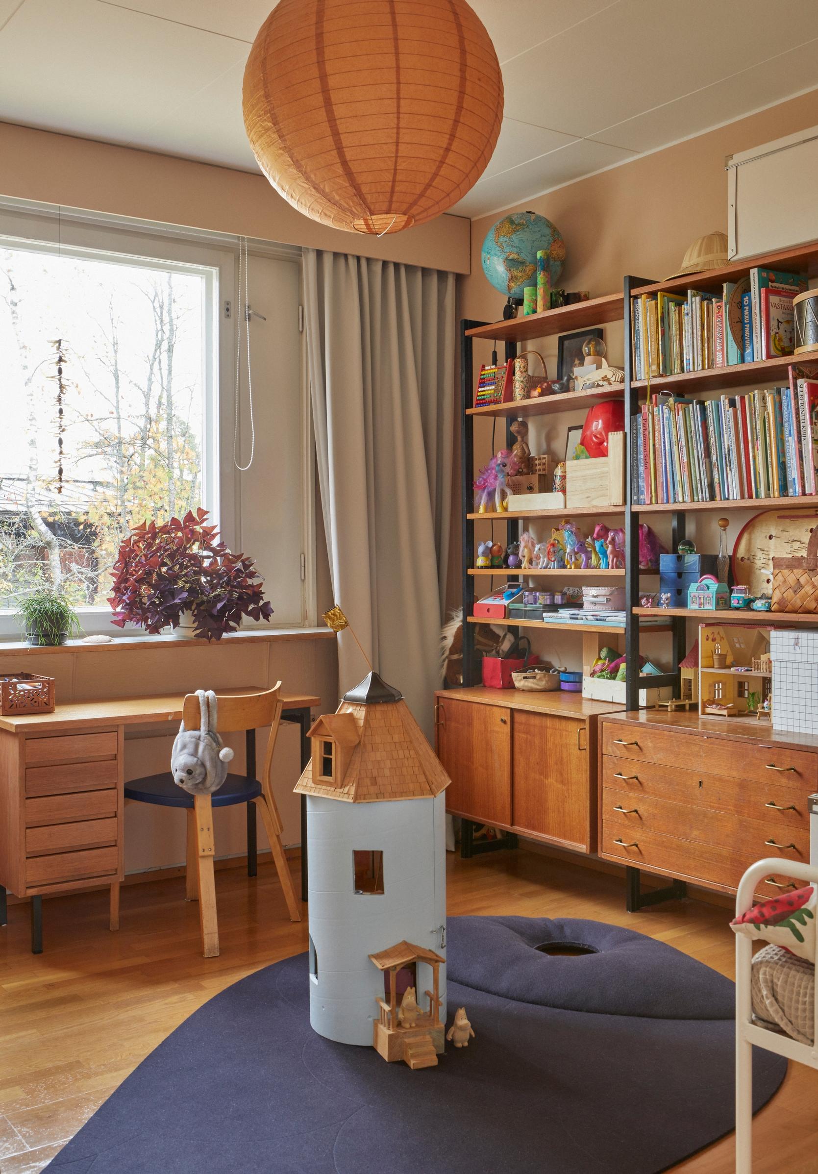 A bookshelf and a handcrafted Moomin house in the children’s room, borrowed from a friend.