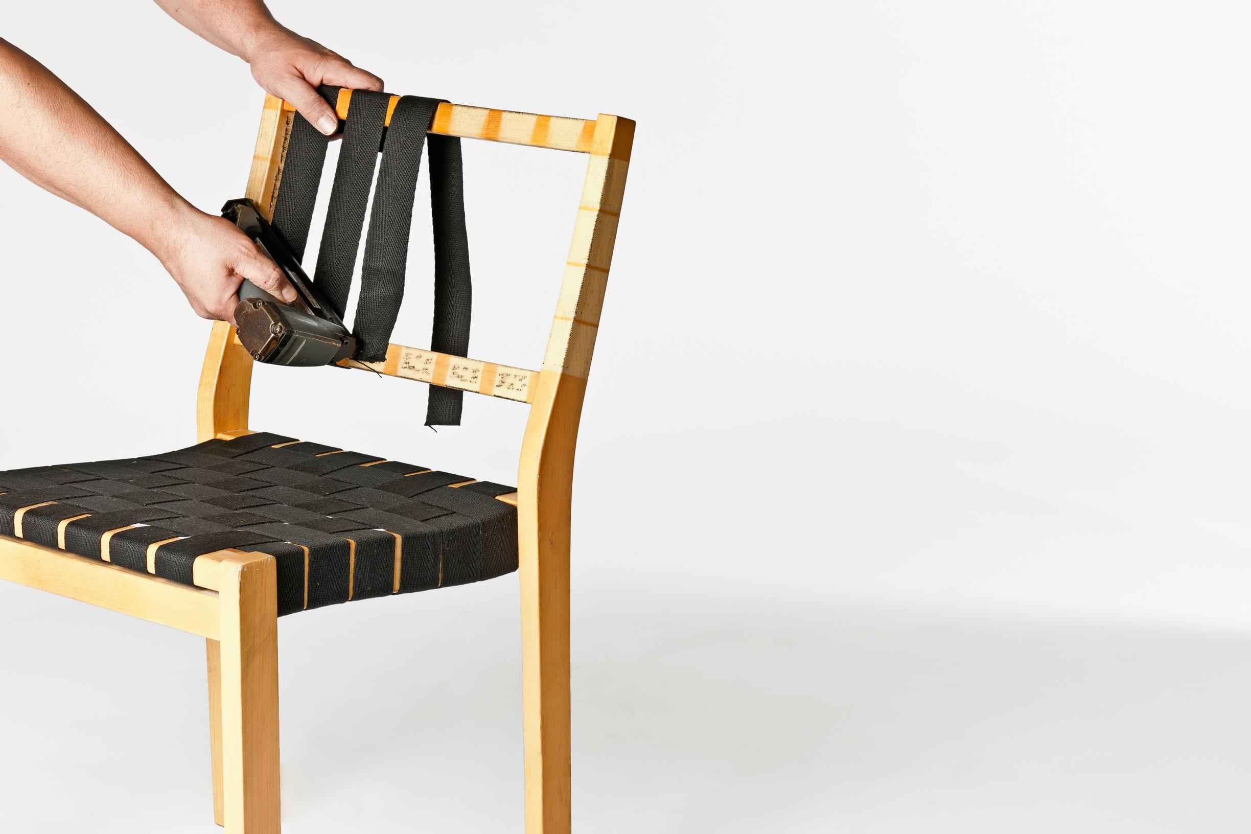 A saddle-strap chair being repaired.