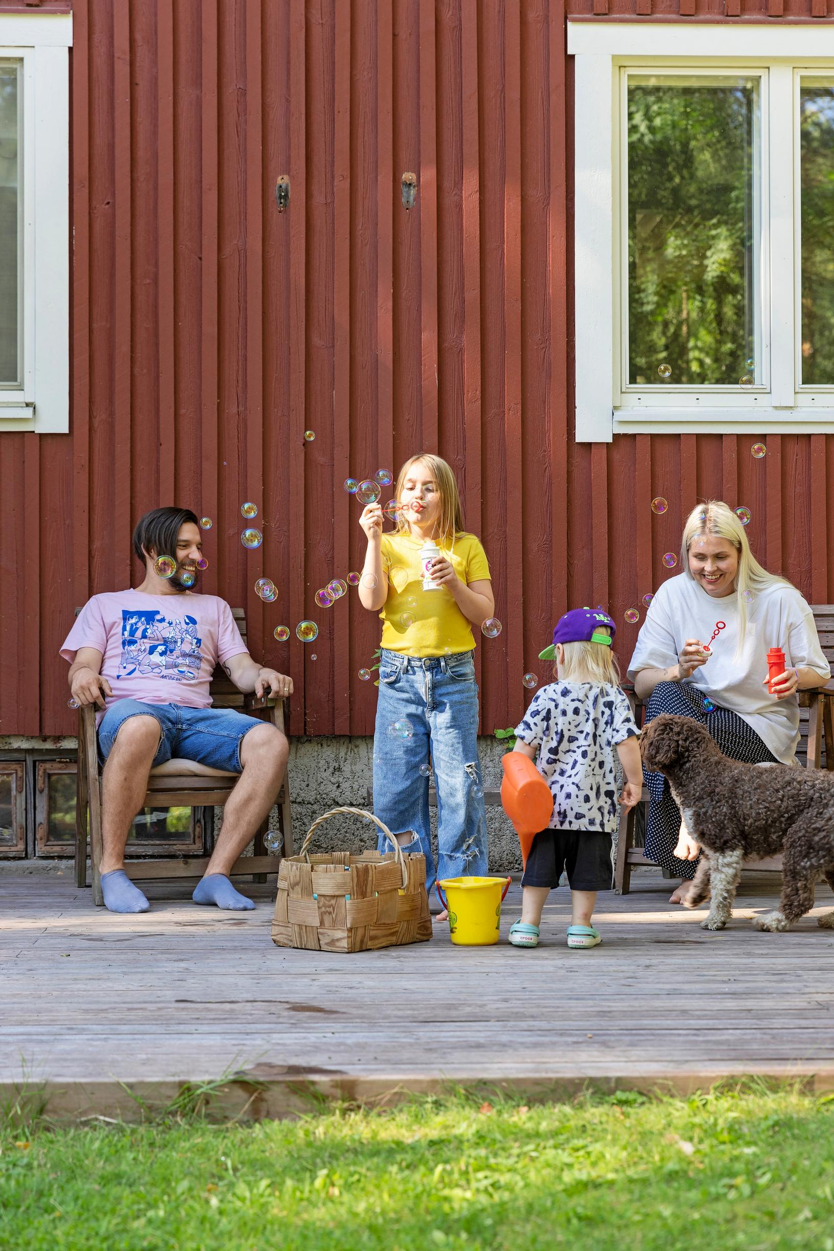 Mikko Virtanen and Essi Hellén blowing soap bubbles with their children