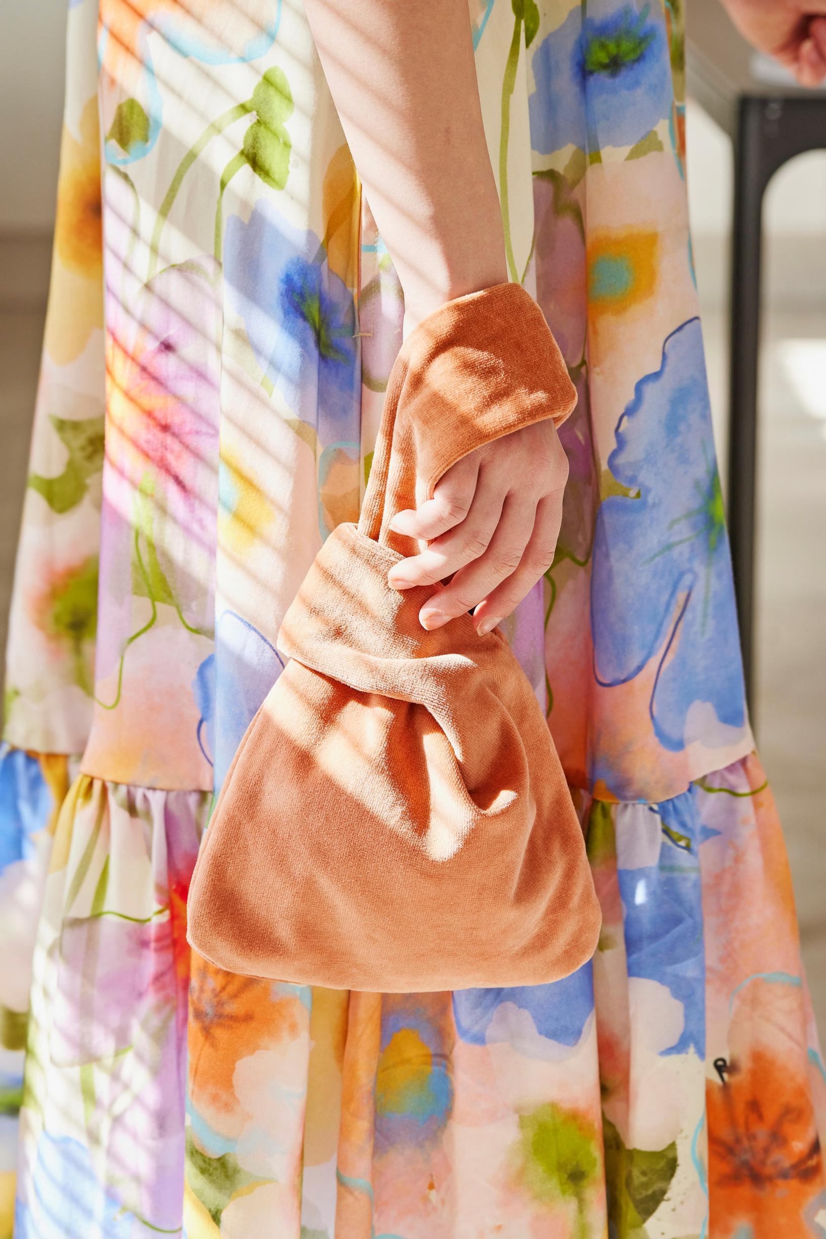 The small knot bag on the wrist.