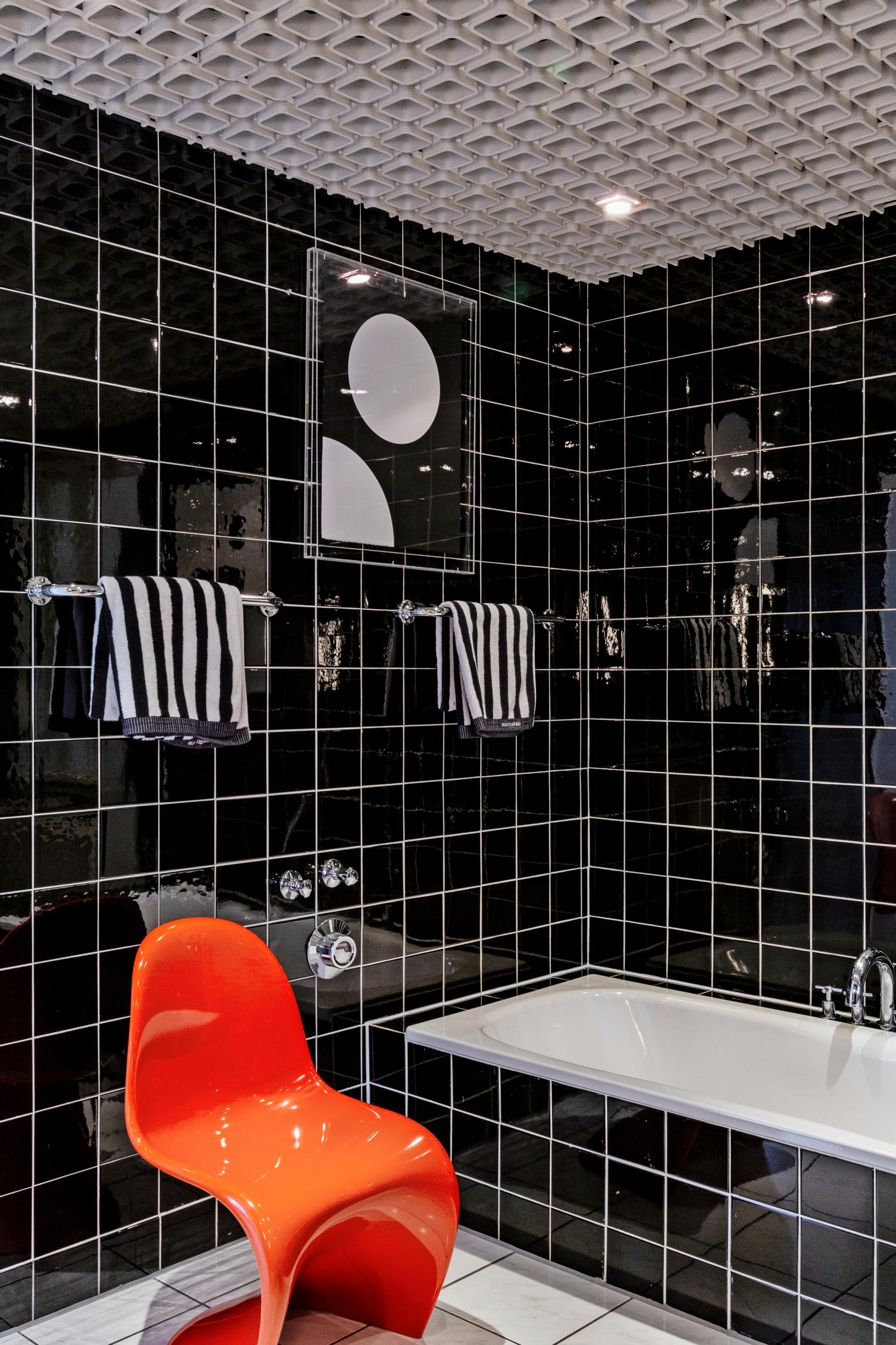 A red Panton Chair in a black bathroom