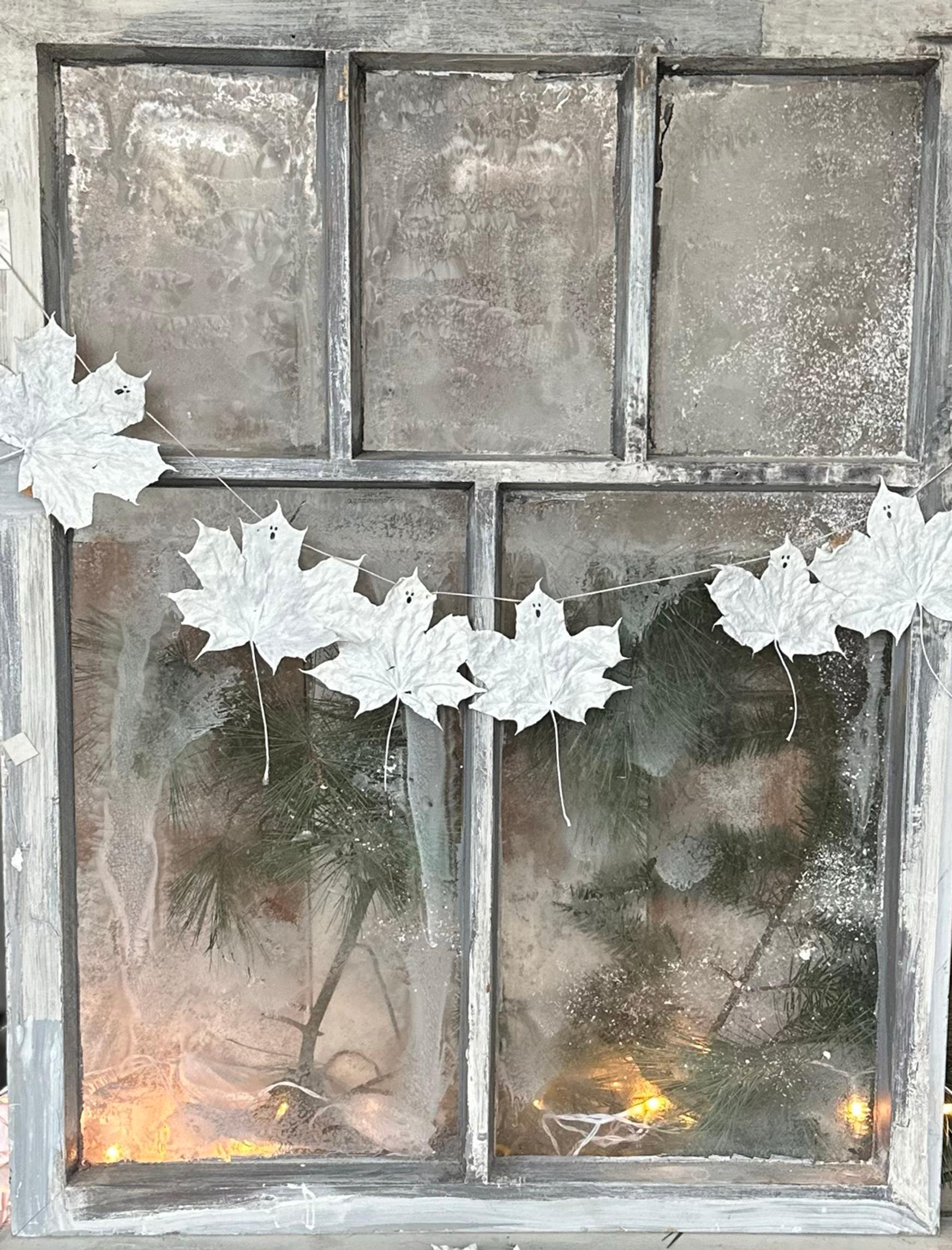 Maple leaf ghosts hanging in a window.
