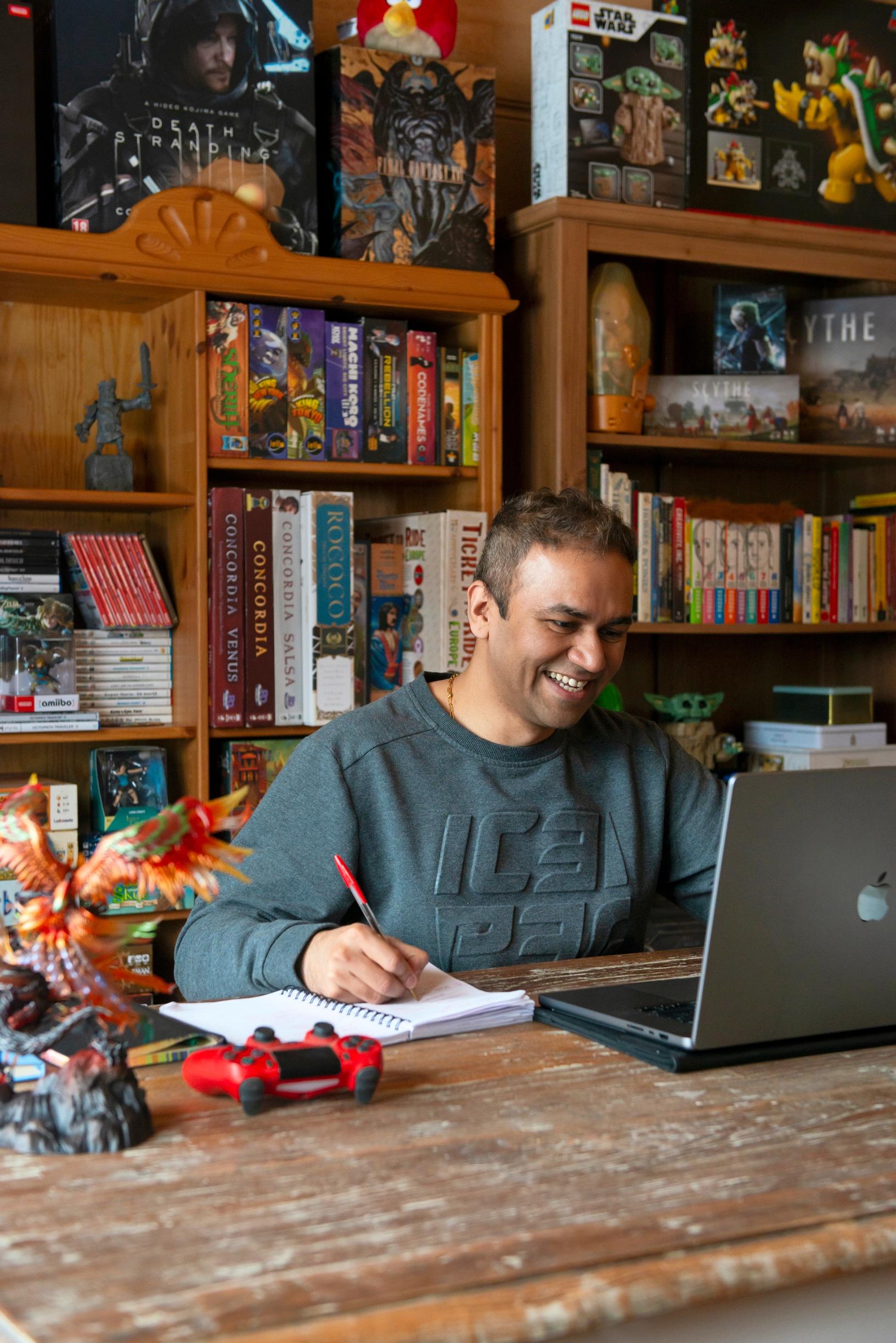 man sitting with a laptop, smiling