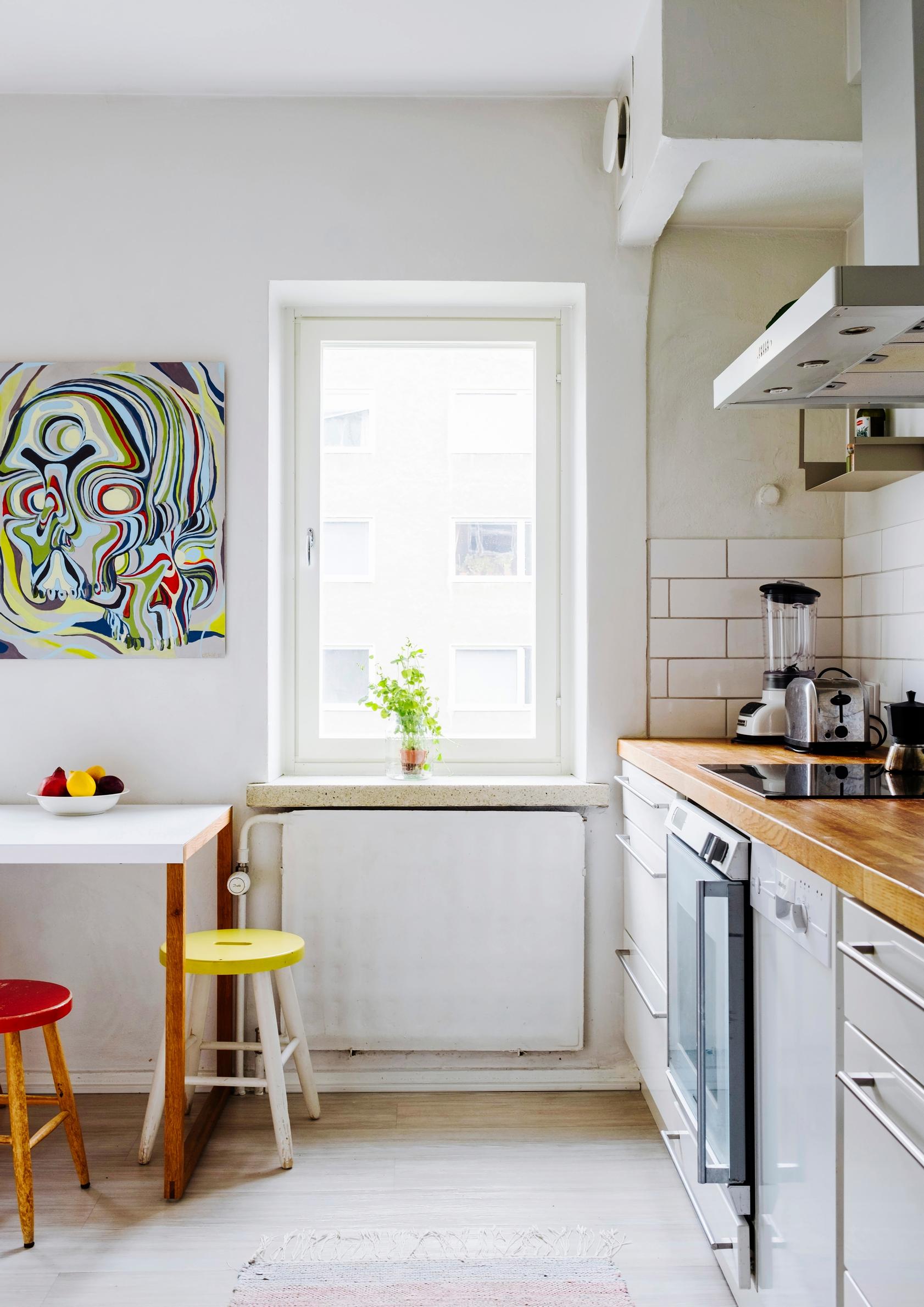 A light-colored kitchen with stools adding pops of color