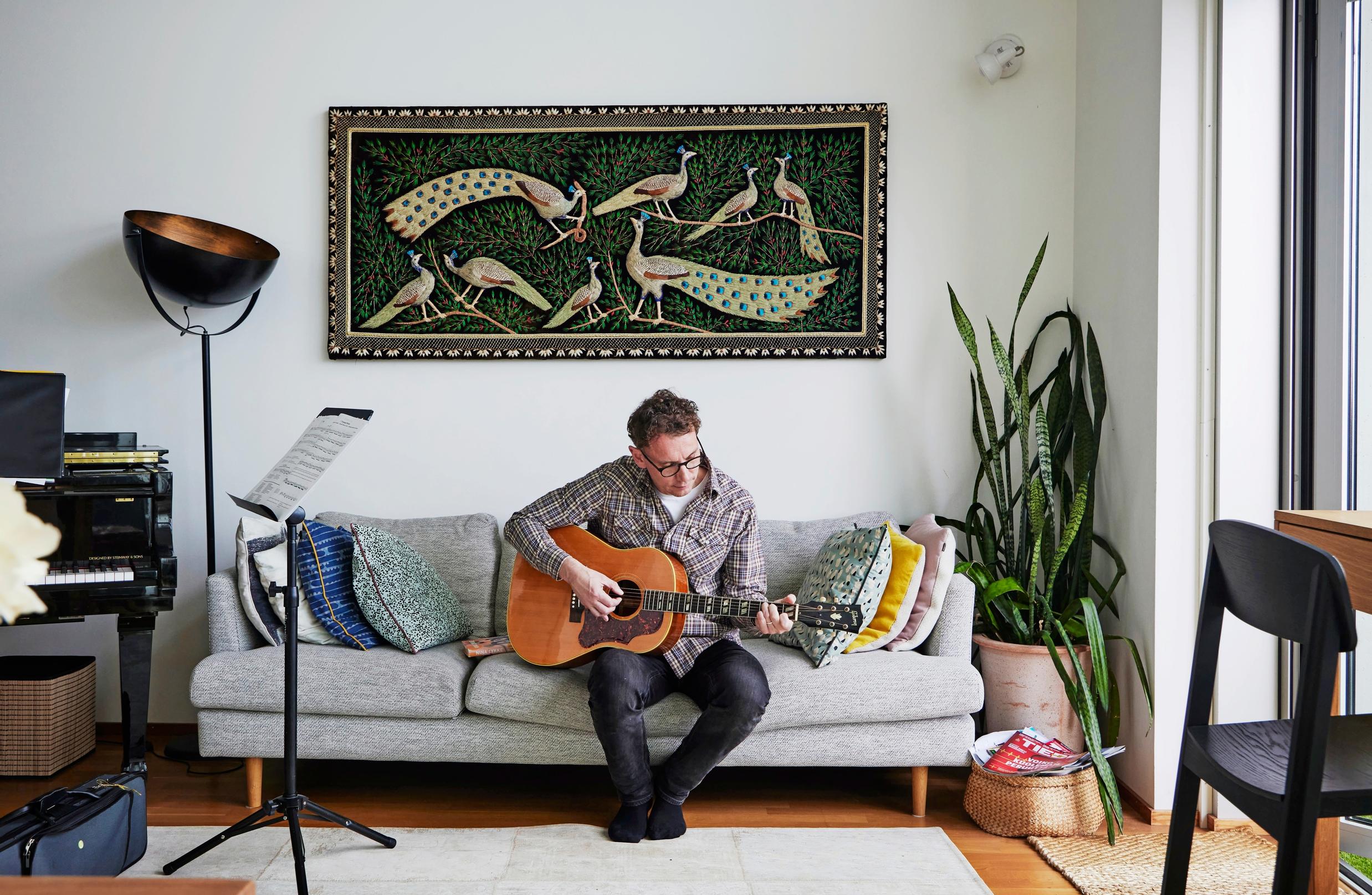 Juha Itkonen playing guitar on the couch