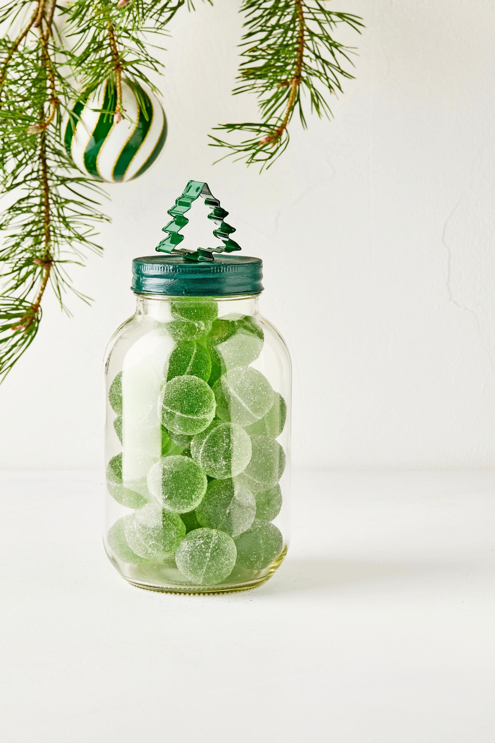 The glass jar is decorated with a tree-shaped cookie cutter attached to the lid with hot glue.