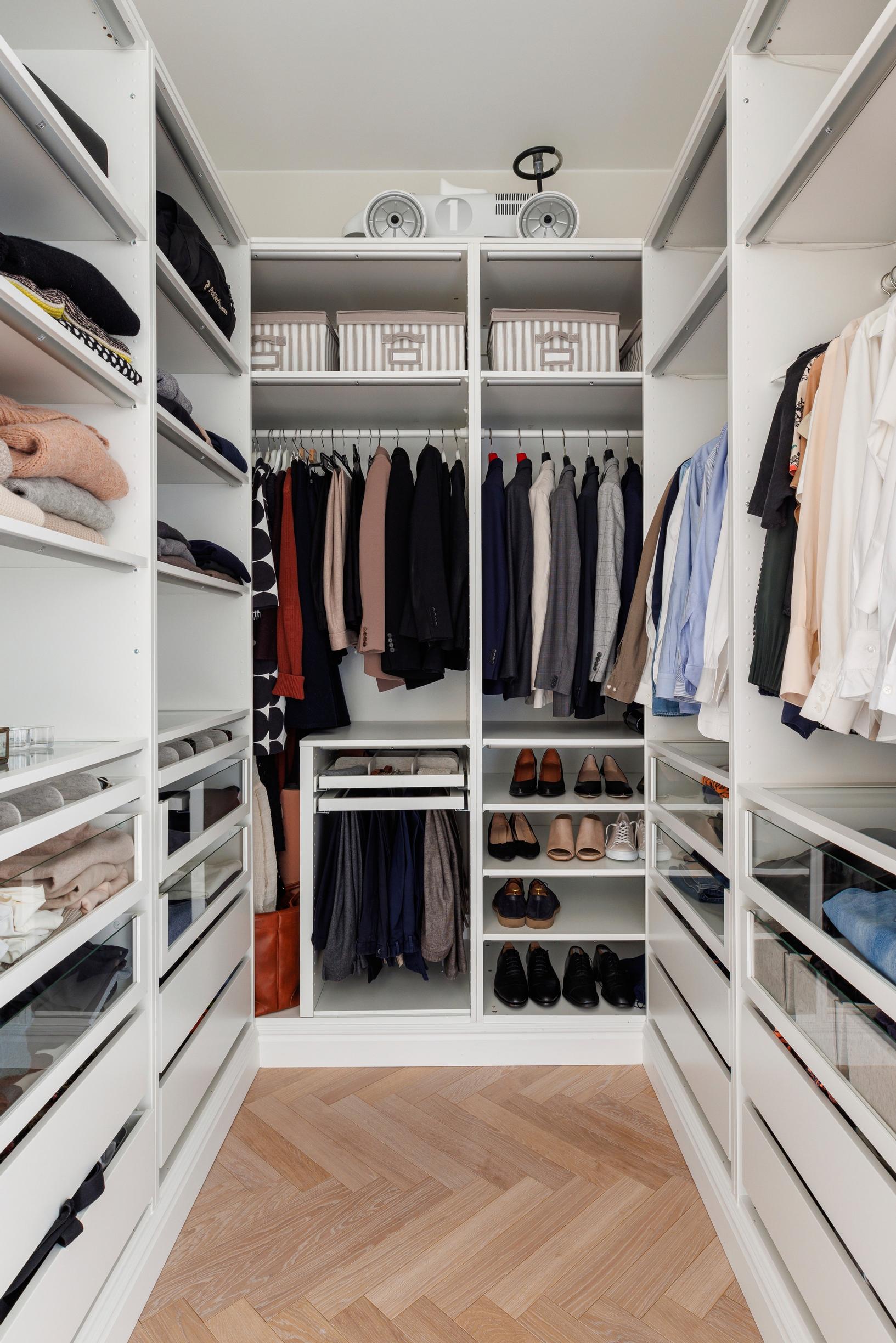 A walk-in closet with wardrobes along three walls.