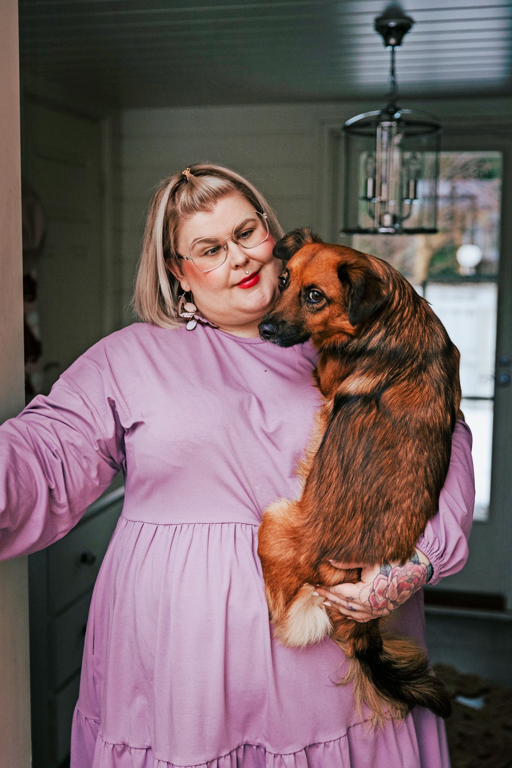 a woman holding a dog in her arms