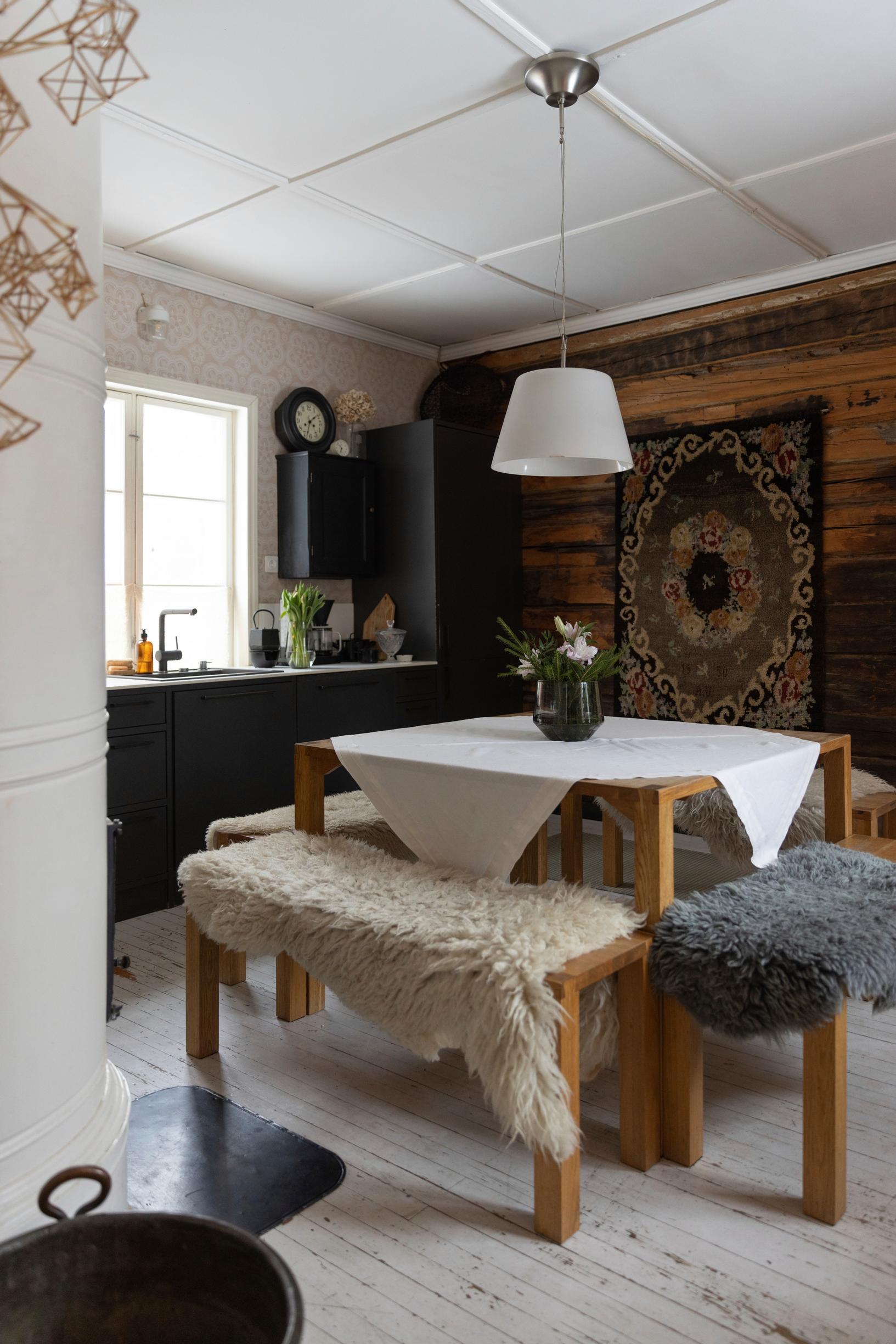 A ryijy tapestry on the kitchen’s log wall.