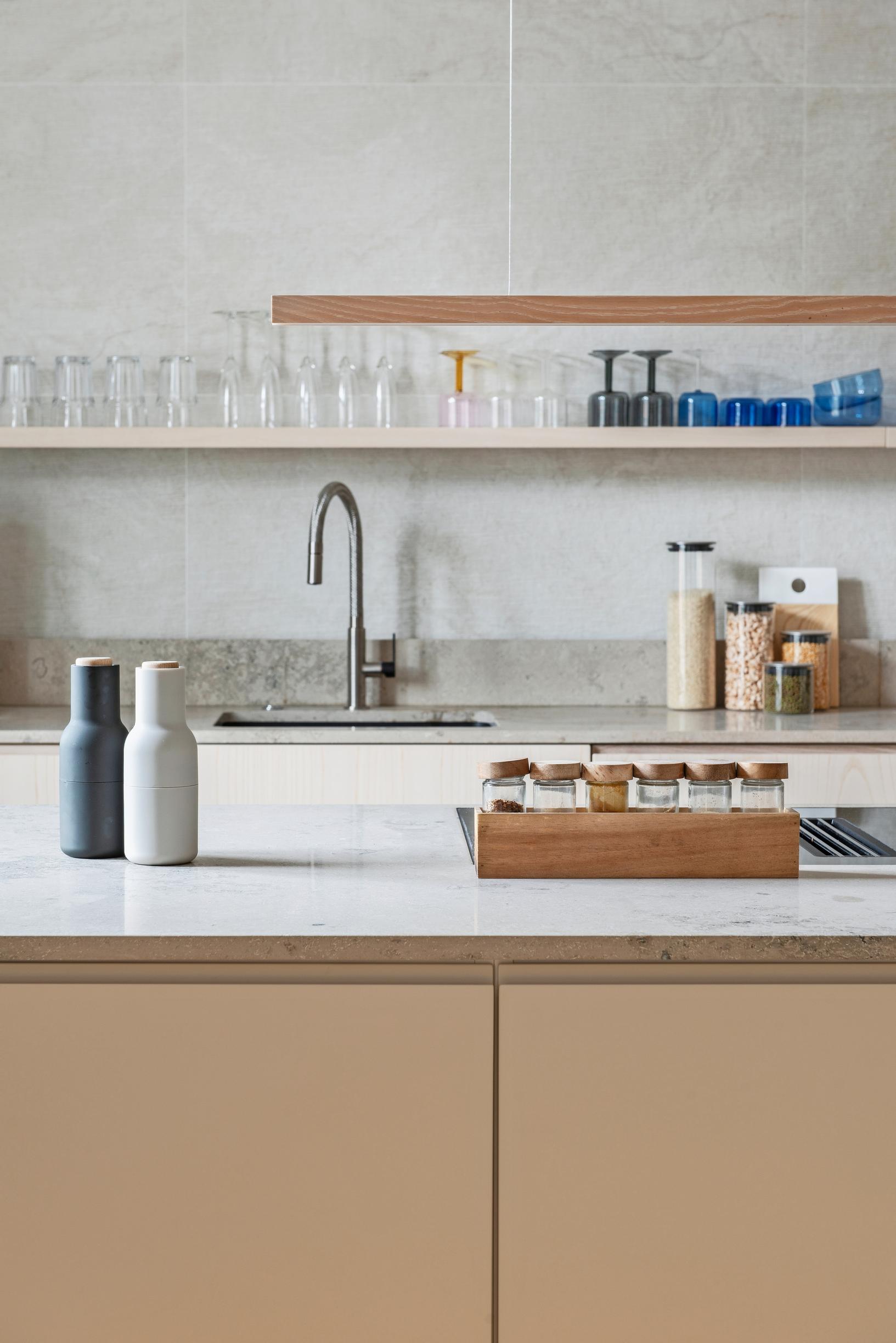 A custom beige-painted kitchen without upper cabinets