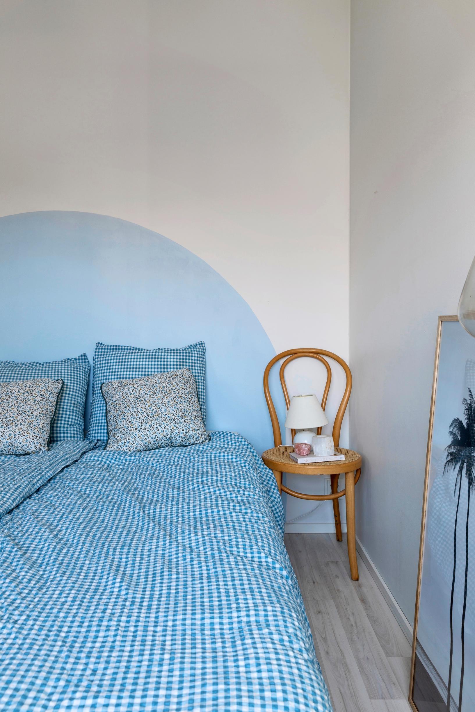 A semicircle painted on the wall serves as a headboard.