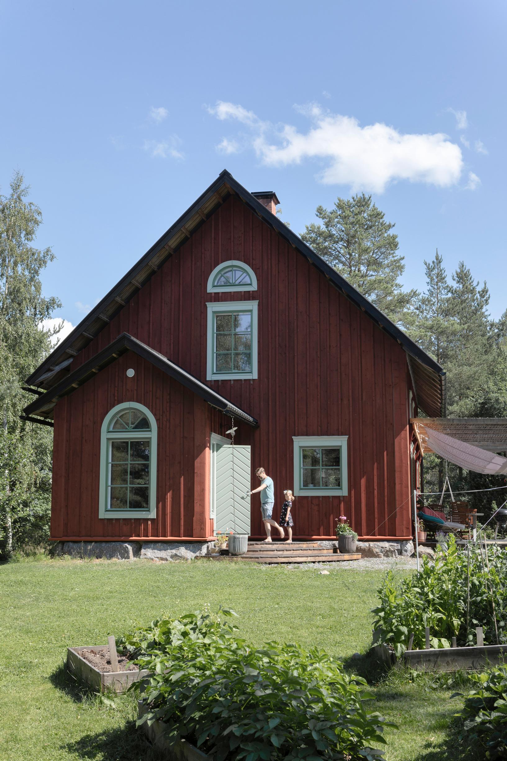 A red-ochre wooden house with a pitched roof