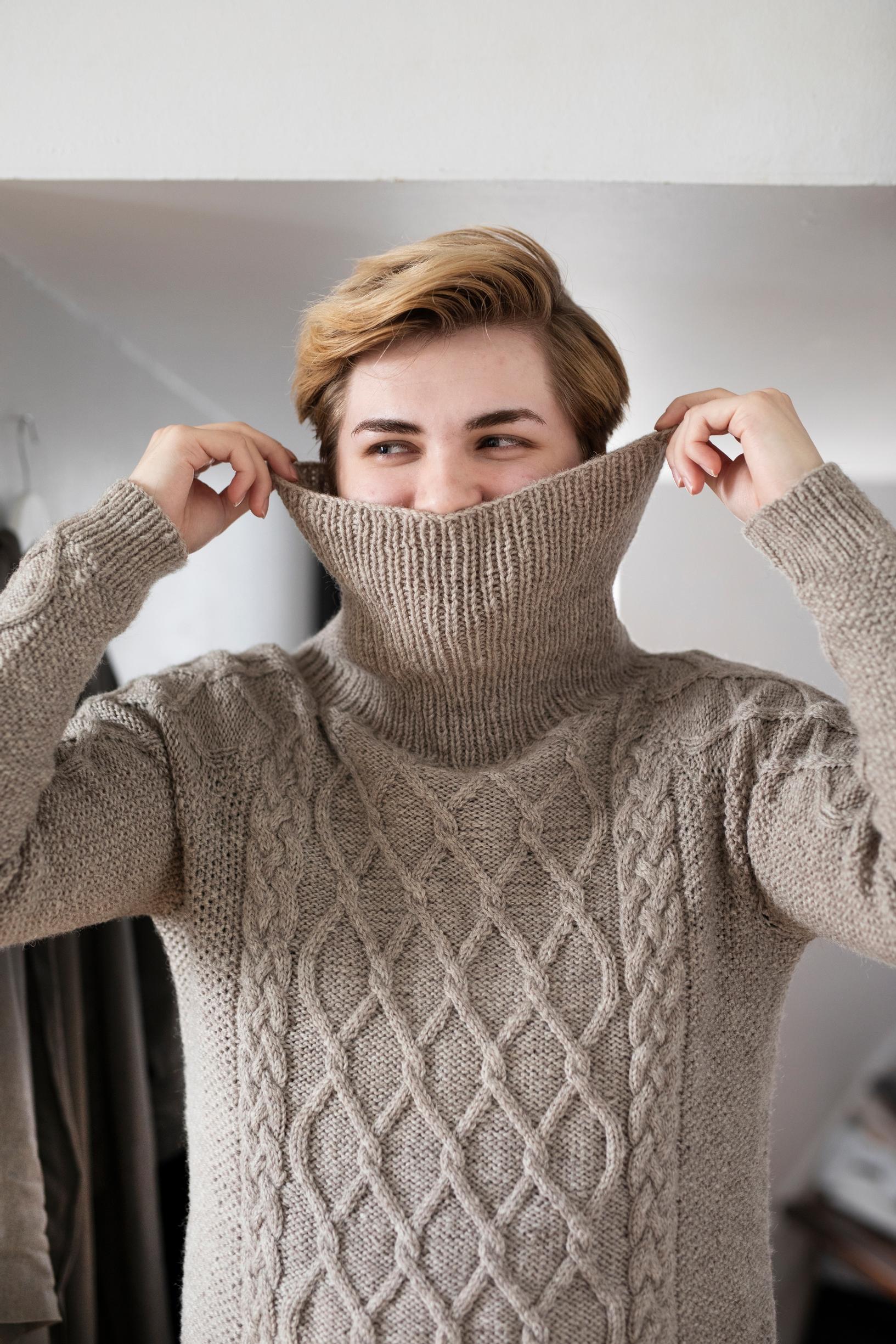 Joona Höri pulling the sweater’s collar up over his face.