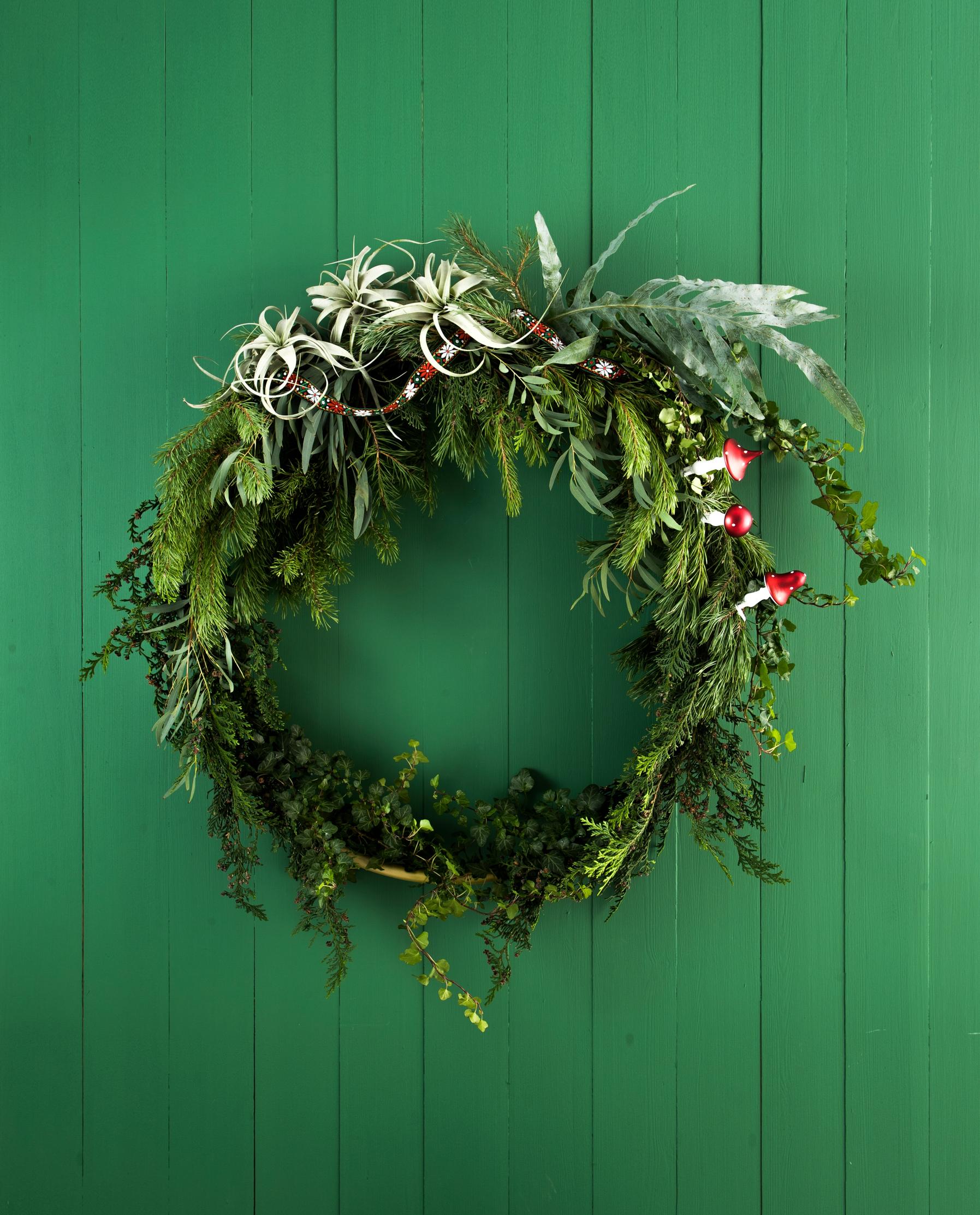 A green Christmas wreath tied around a hula hoop.