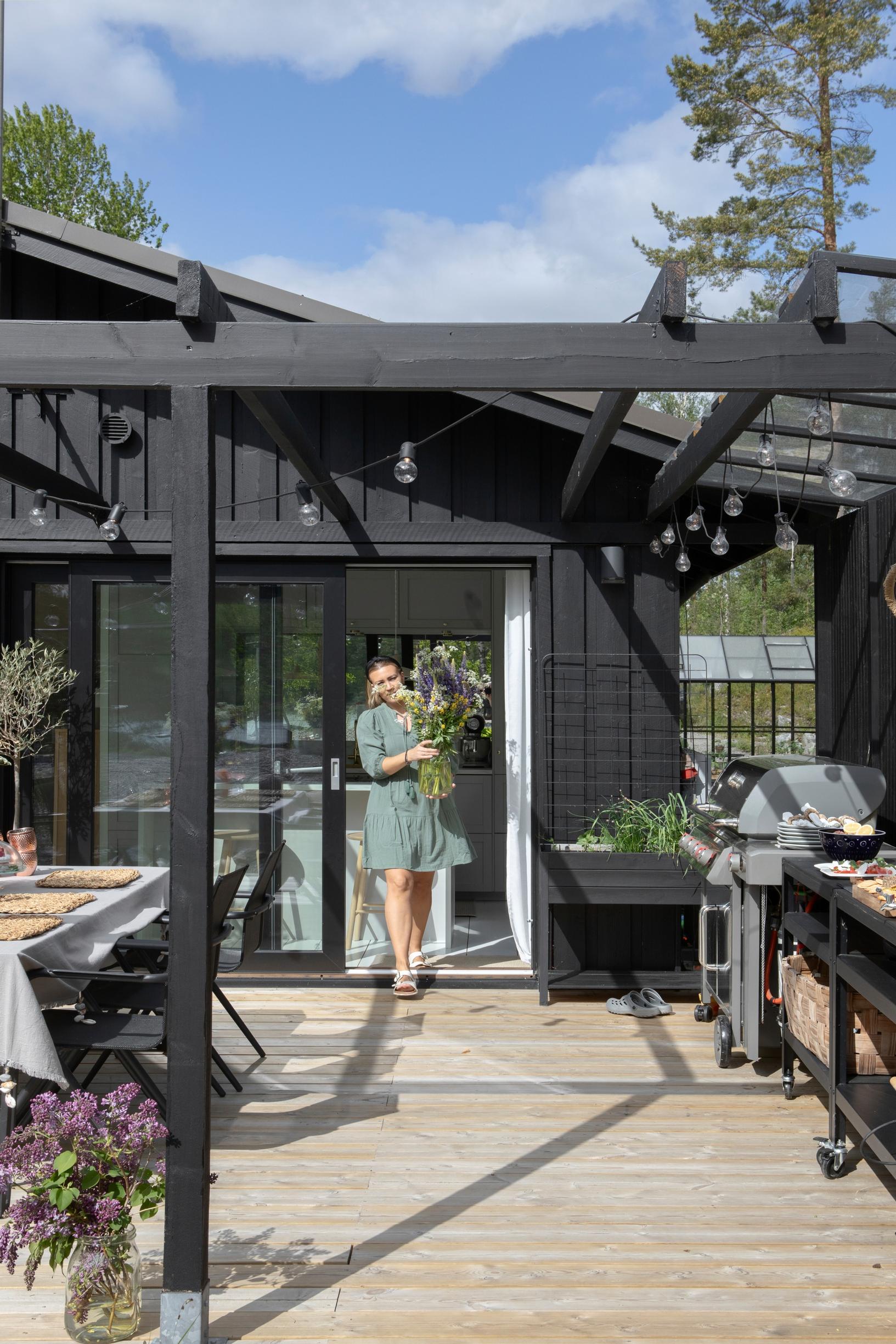 Nicolina steps onto the deck from the end of the house