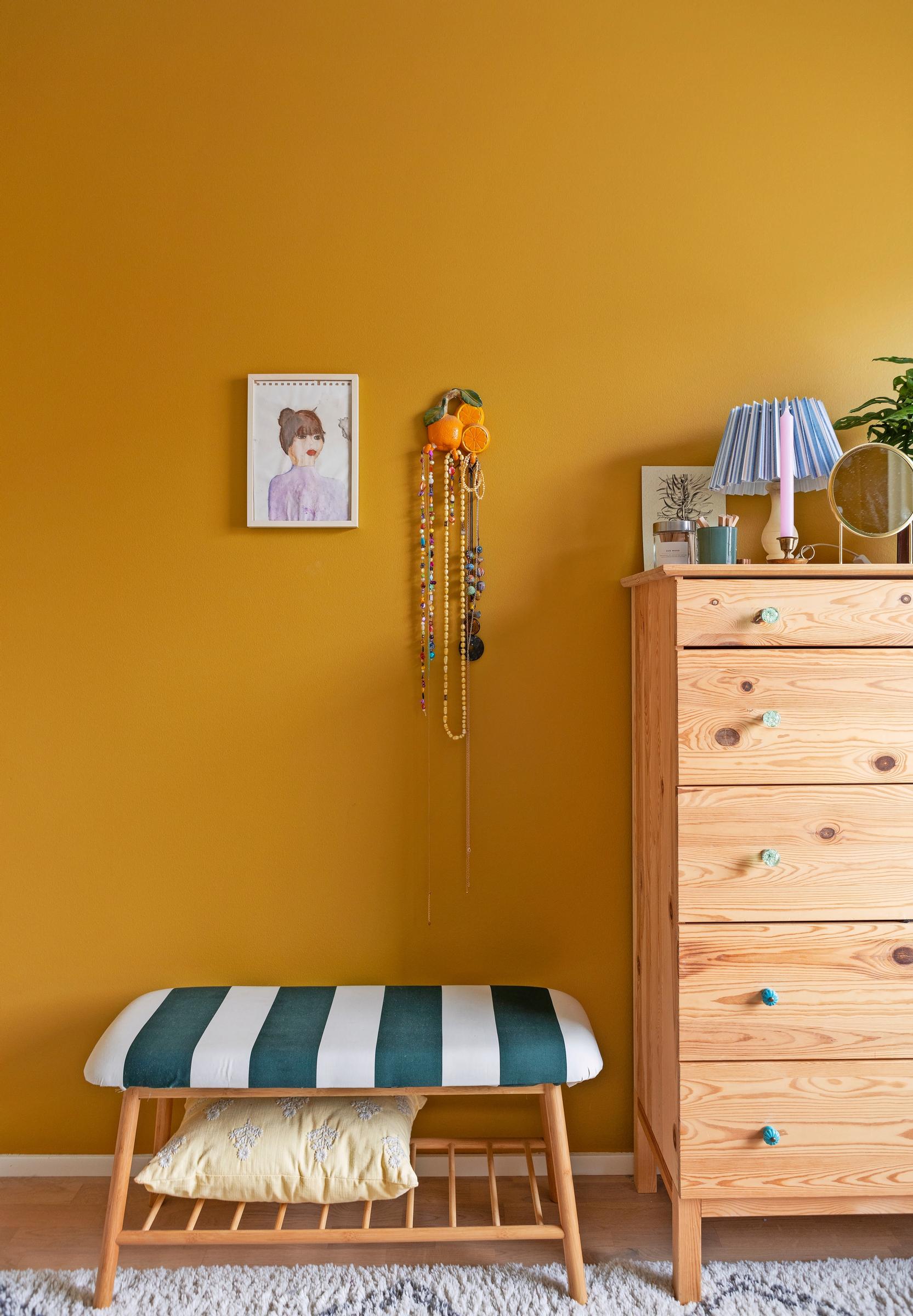 Photo of a wooden dresser and the updated bench against a yellow wall.