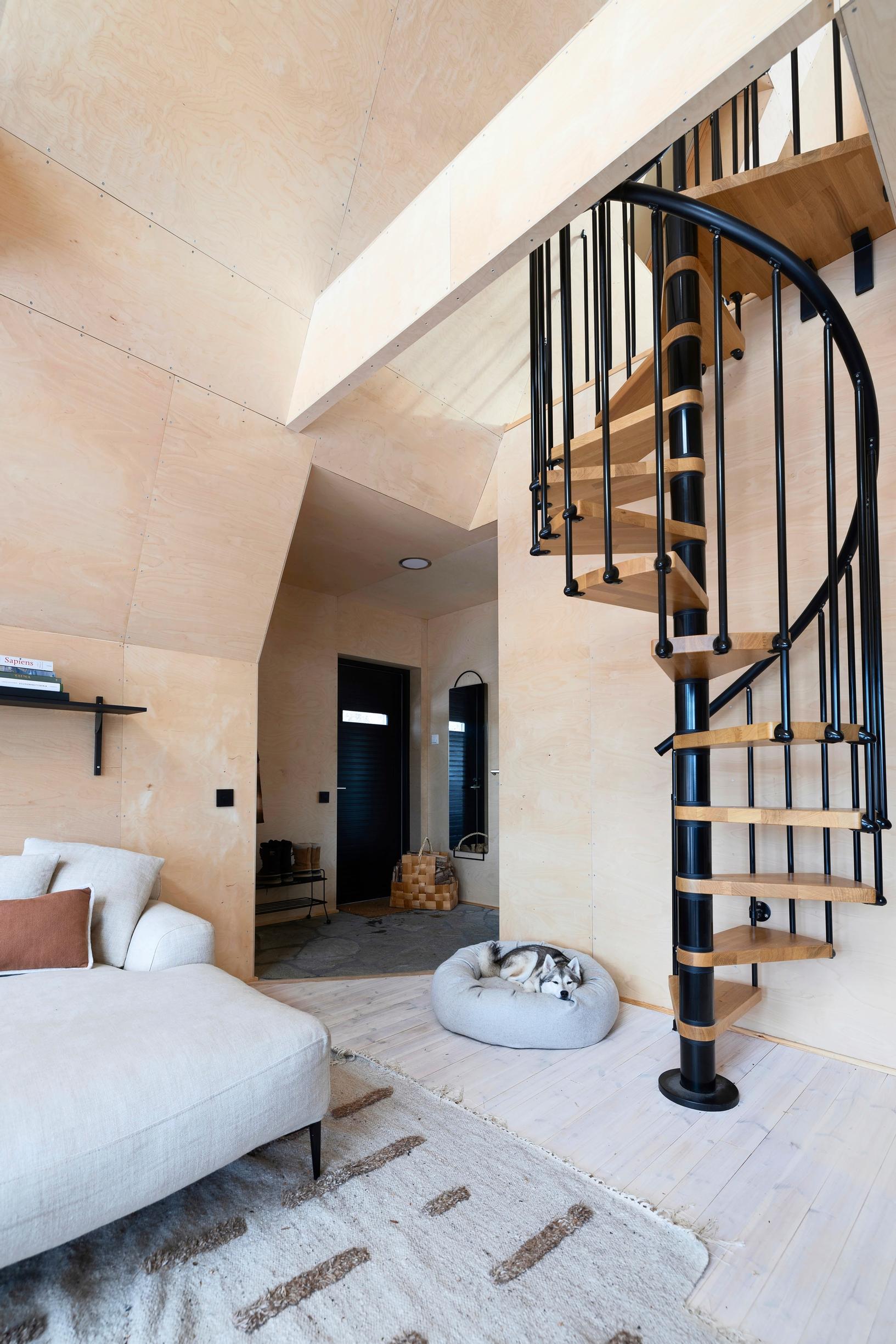 A spiral staircase rises from the living room to the upper floor