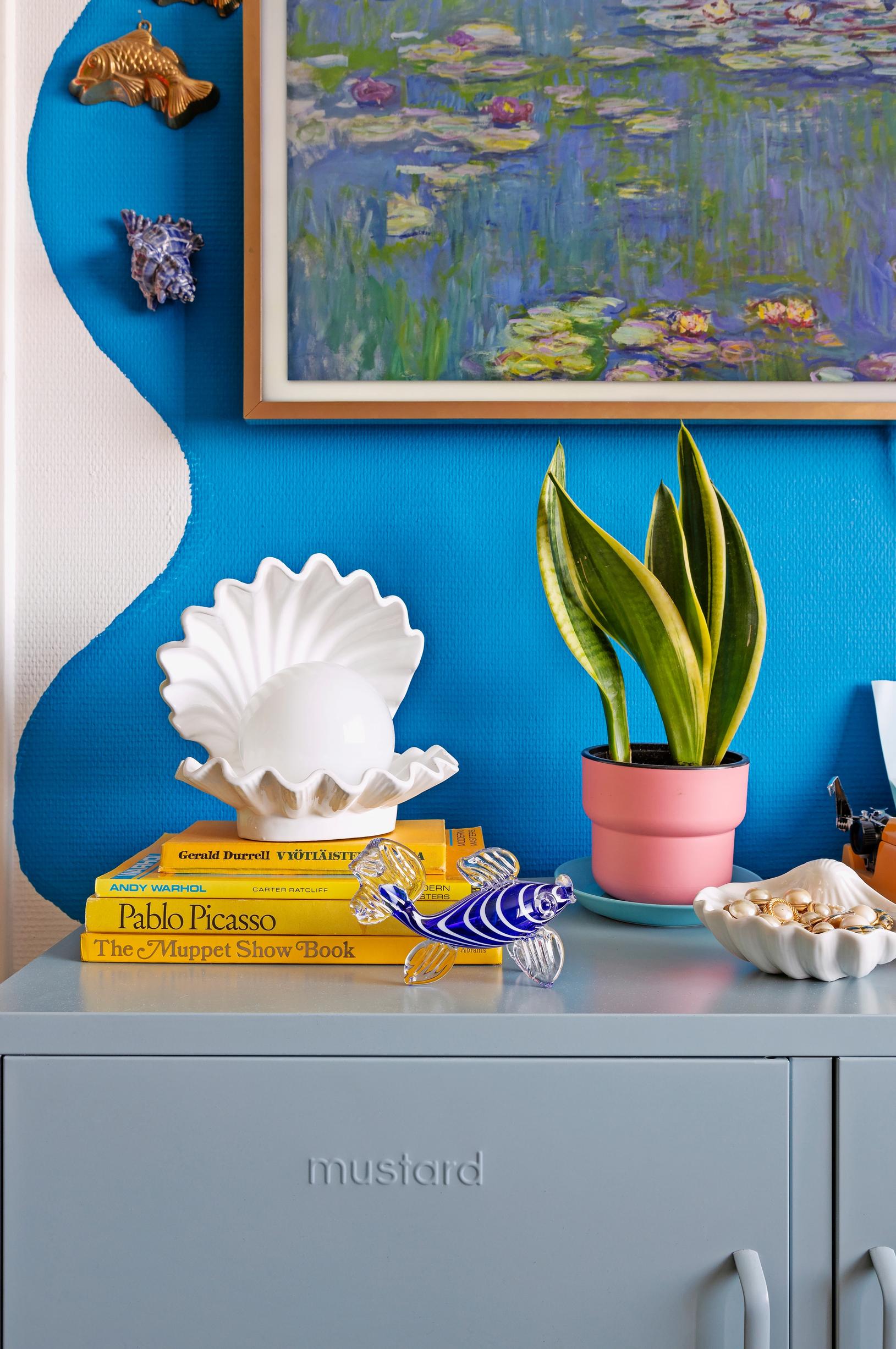 An arrangement of water-themed objects against a blue wall.
