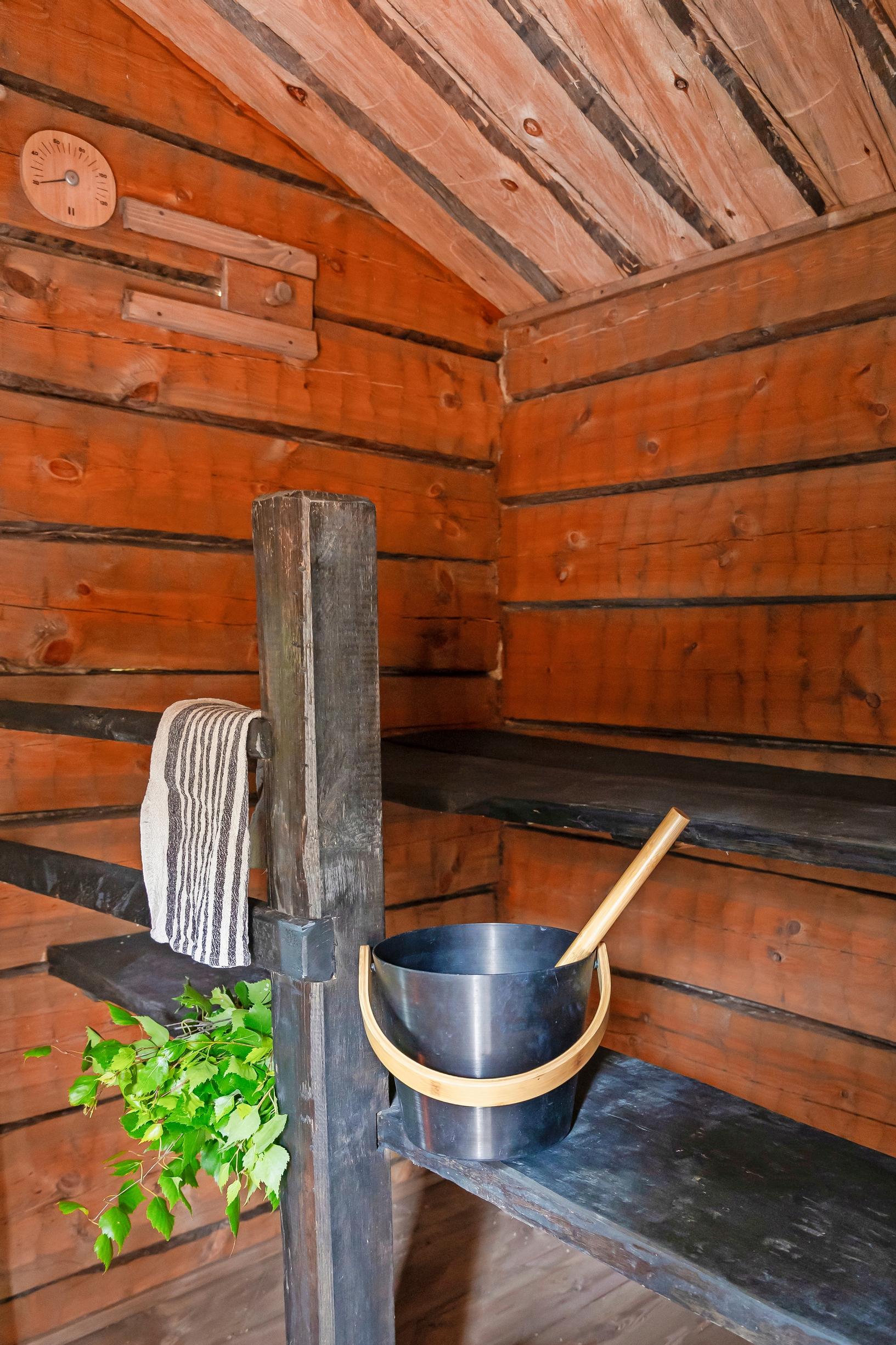 dark benches, a dark sauna pail, and a birch whisk