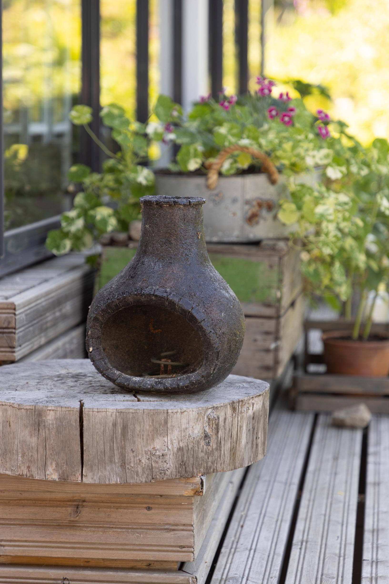 A ceramic container made by Marita for mosquito coils, displayed on a wooden stand