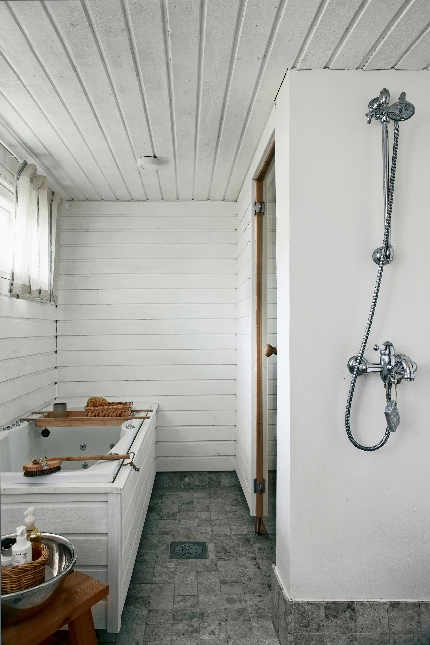bathroom with a whirlpool tub surrounded by paneling