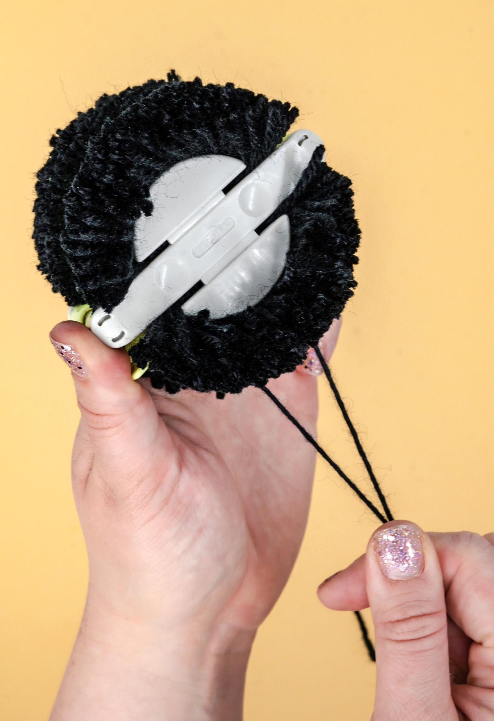 tying the pompom with a pompom maker