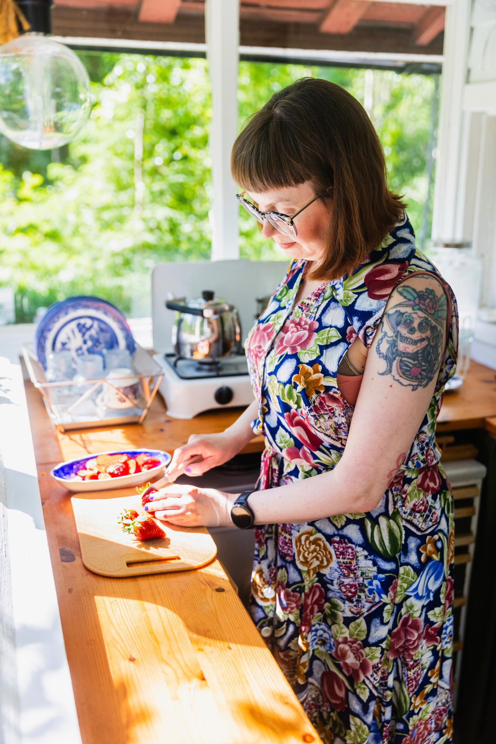 Elina Henttonen slicing strawberries in the cabin