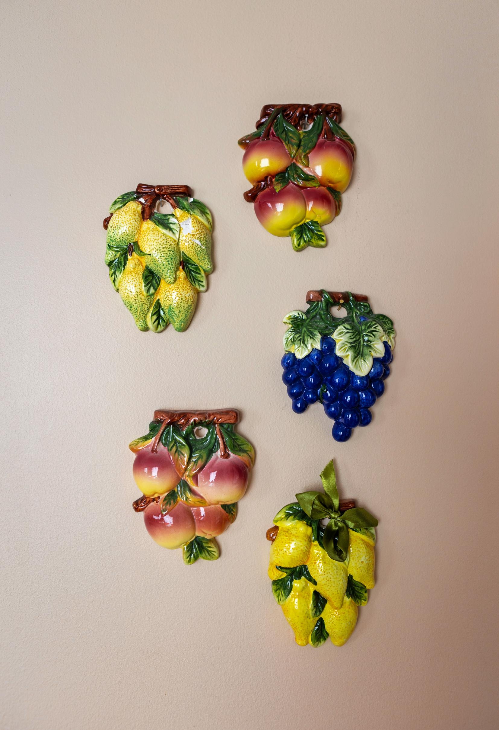 Photo of ceramic fruit wall decorations.
