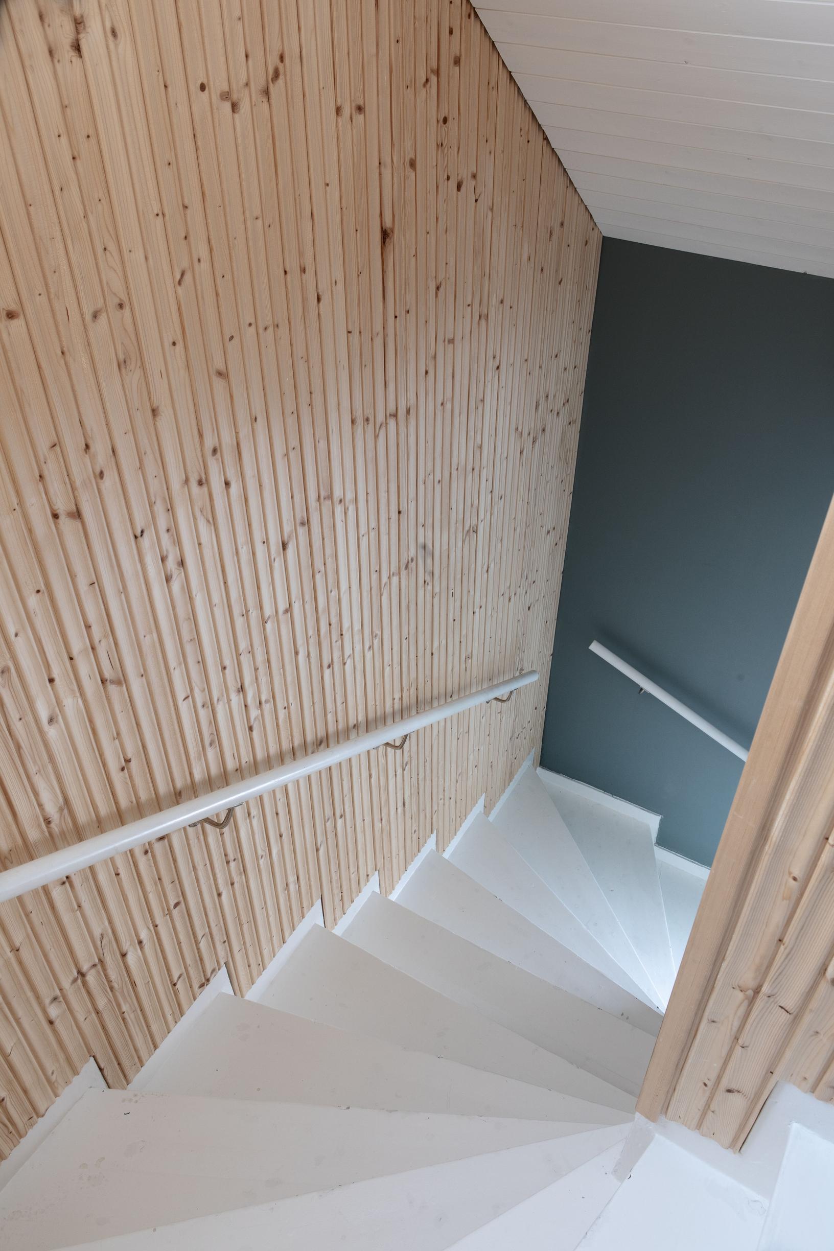 Staircase leading upstairs, with paneled walls.