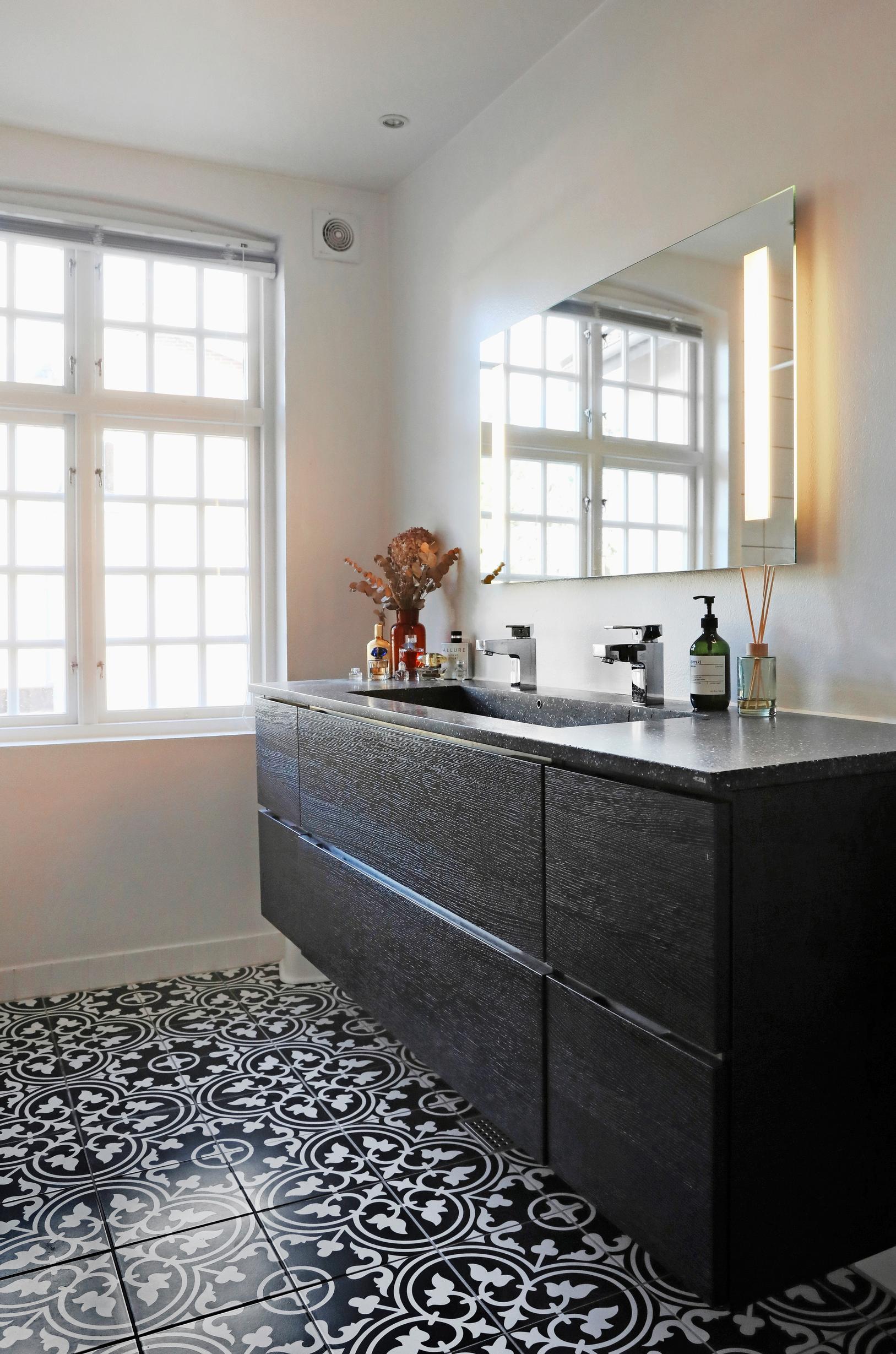 Natural light filters into the bathroom through the mullioned windows.