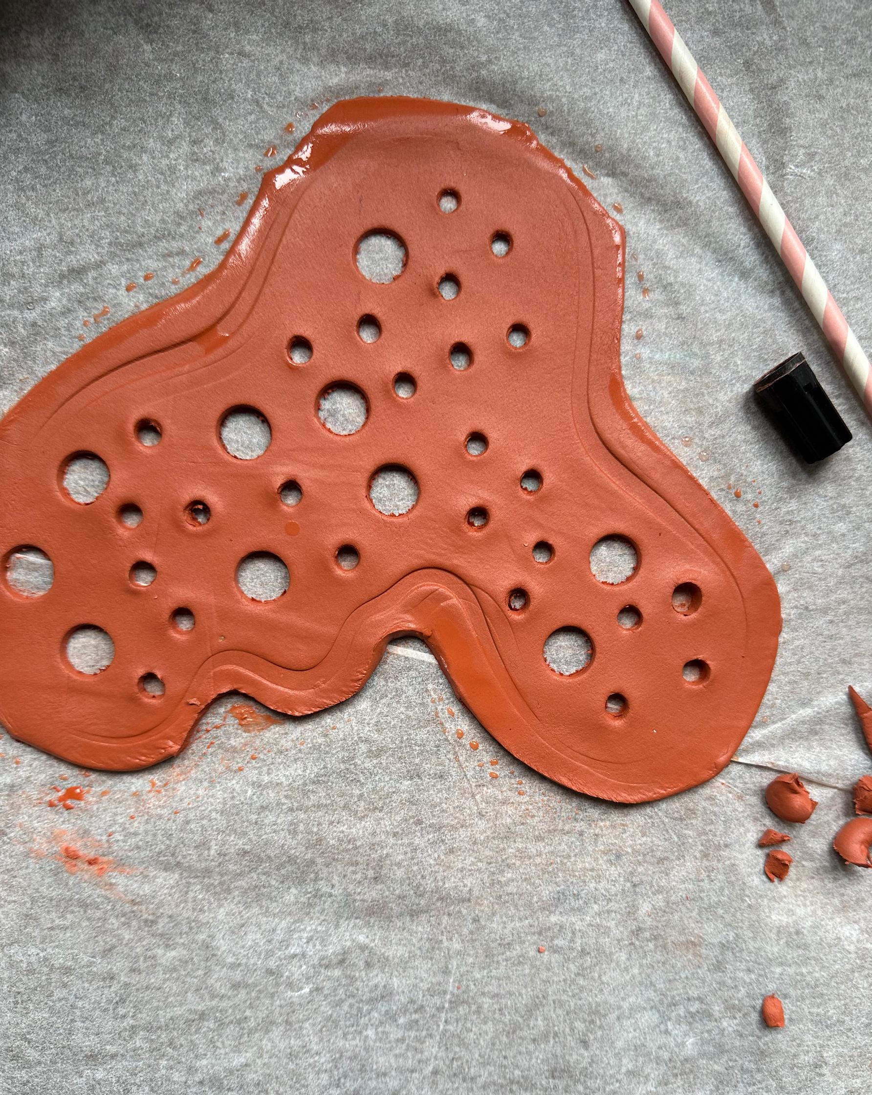 A straw and a marker cap make it easy to create holes in rolled-out air-dry clay.