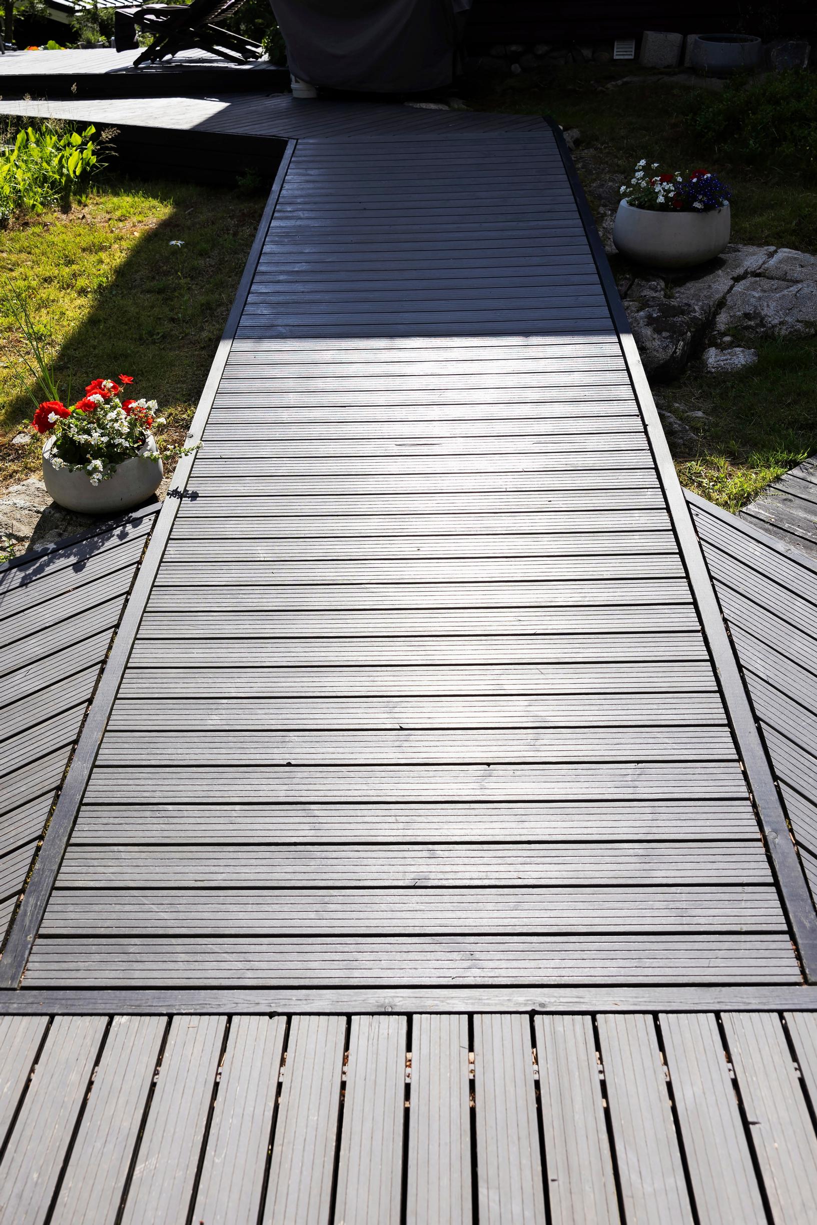 gray pine boards on a walkway and summer flowers