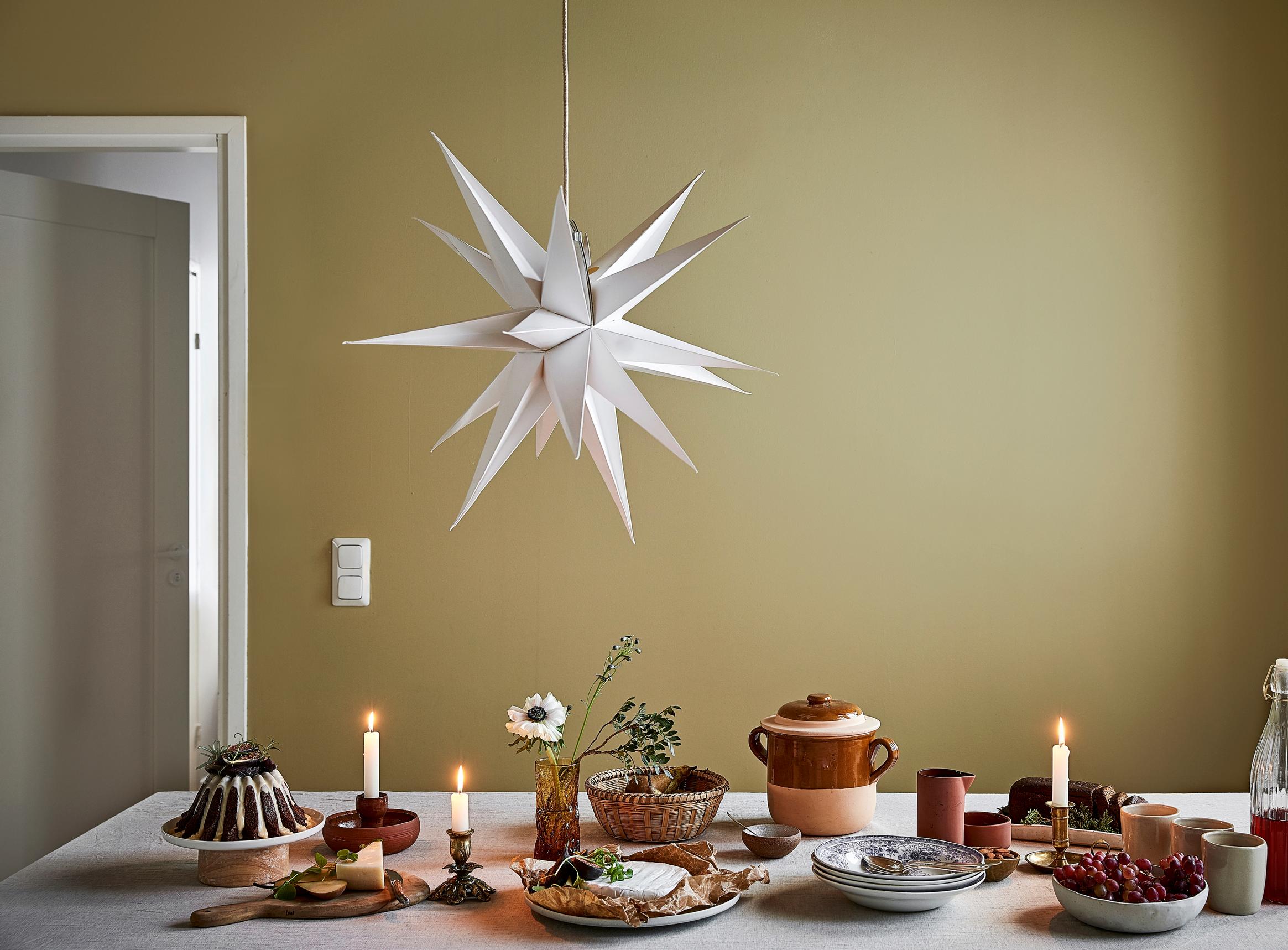 A white paper star hanging above a set table
