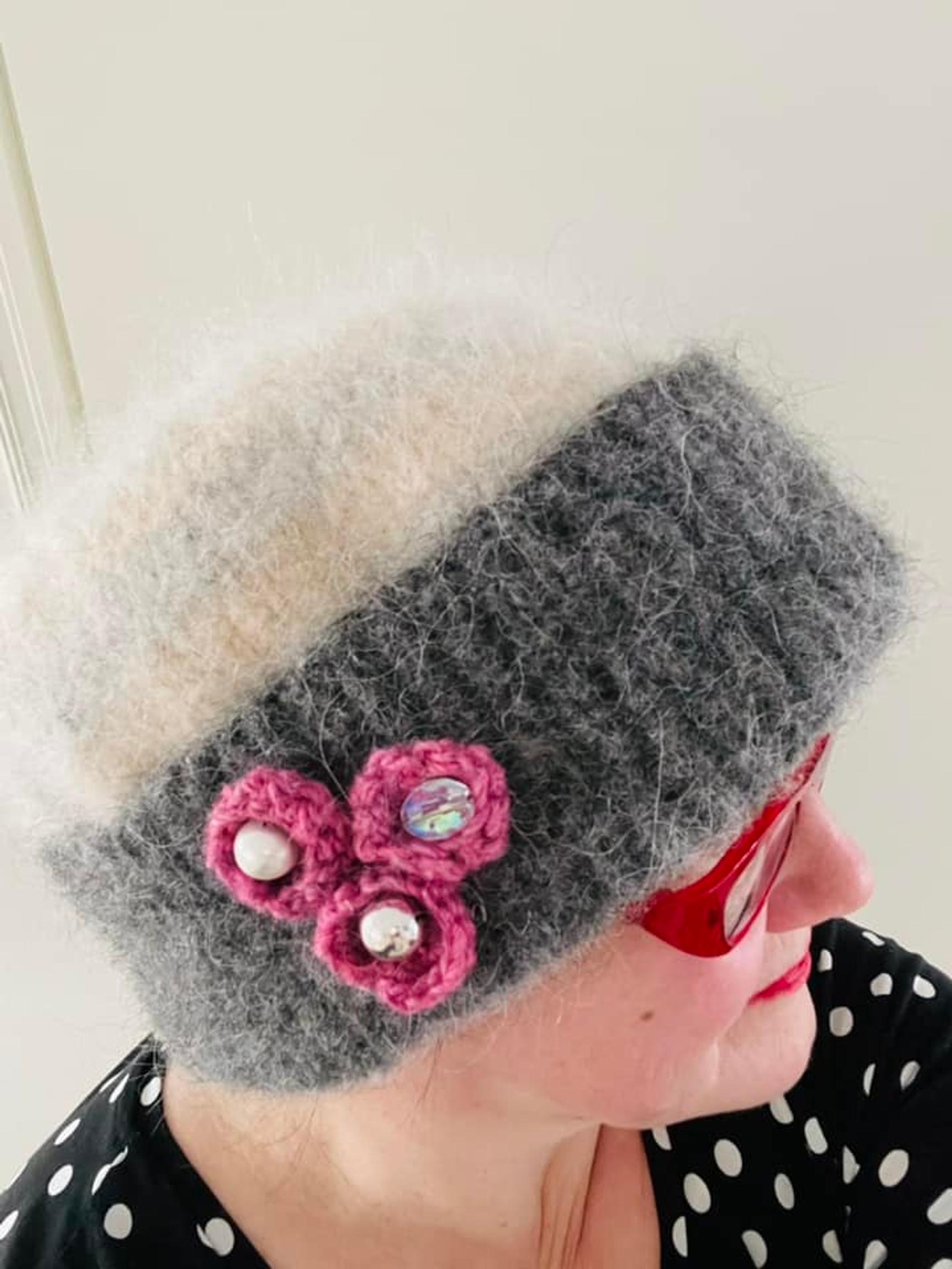 A knitted and felted hat worn by a woman.