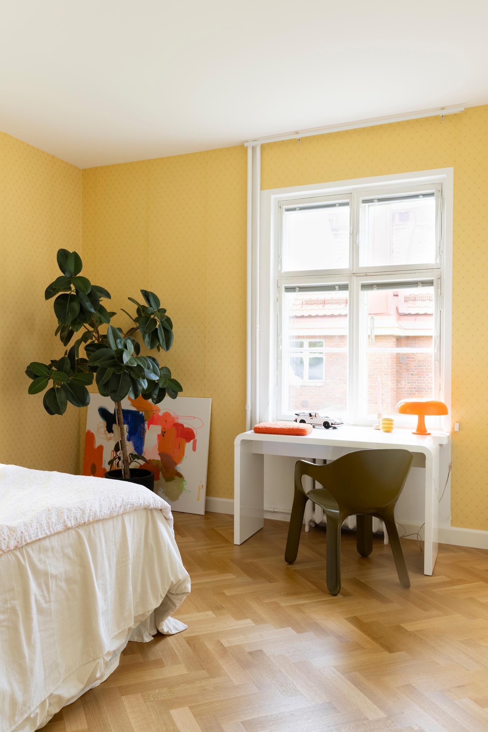 The bedroom glows with the yellow Filipsborg K31-50 heritage wallpaper.