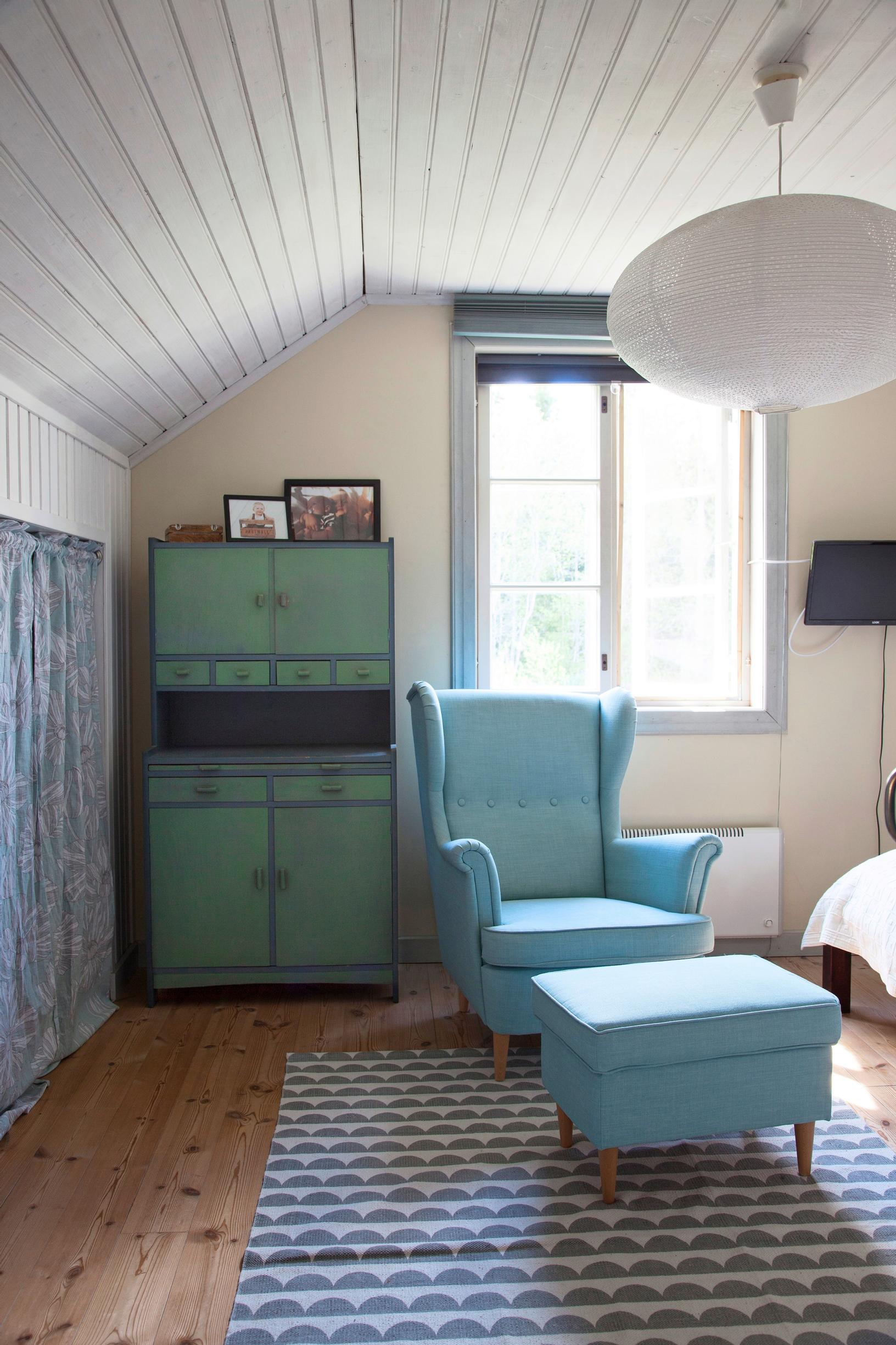A green hostess cabinet and a blue IKEA armchair.