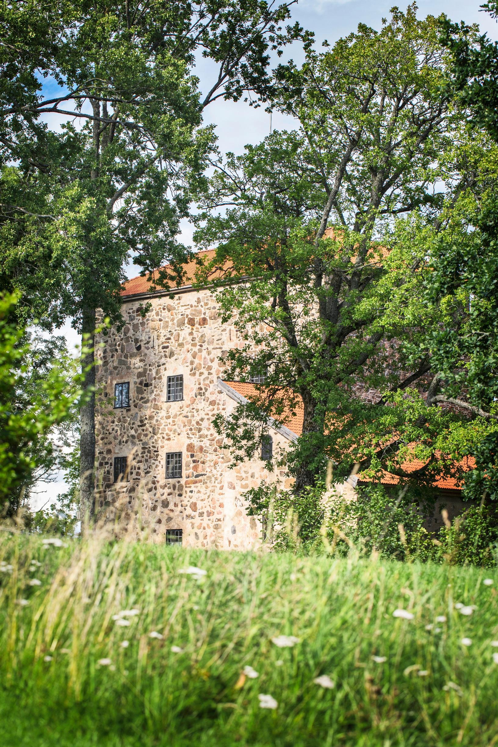 The stone castle of Qvidja tucked among trees