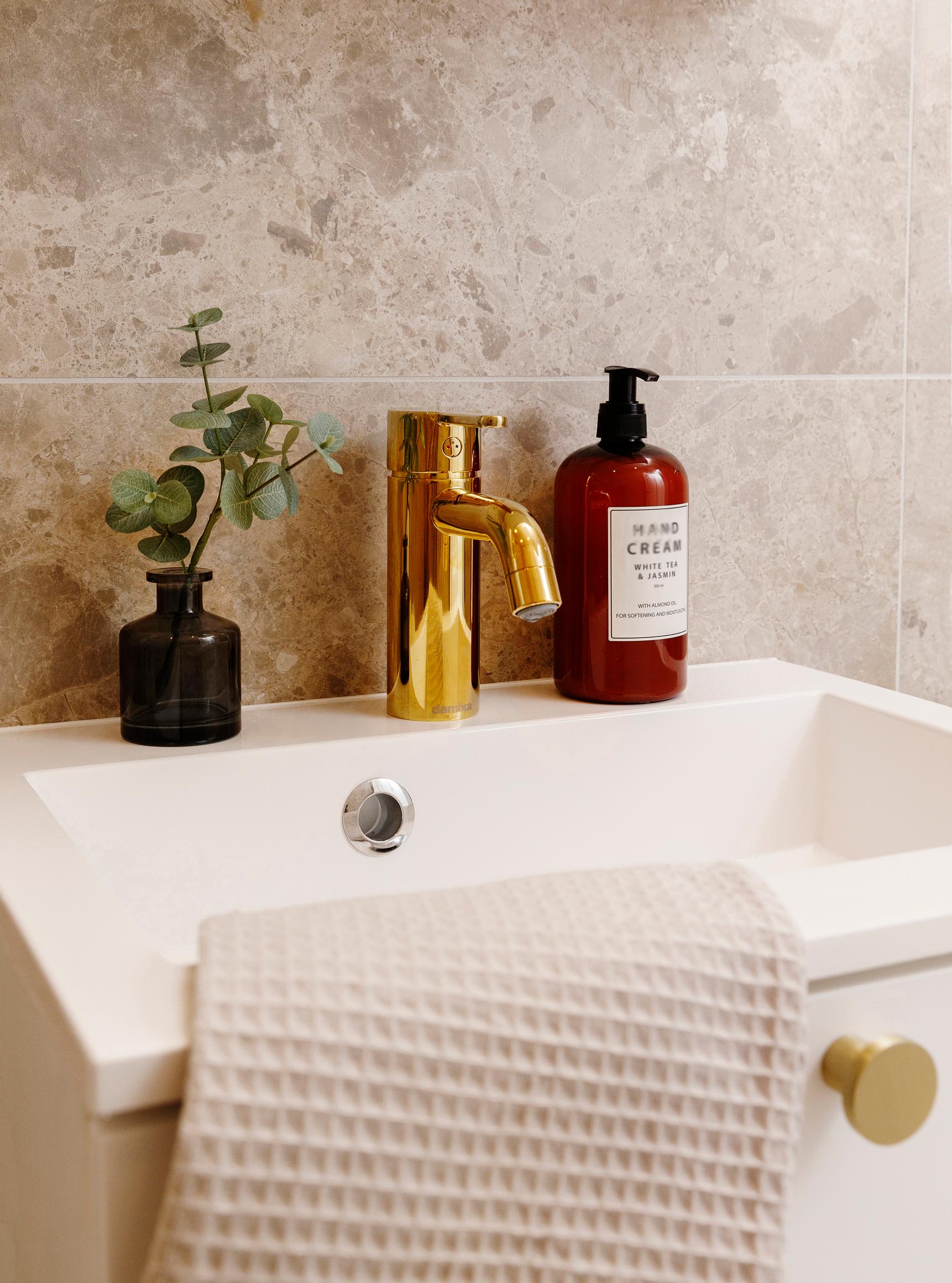 Charmia’s sink cabinet and Damixa’s brass-colored Silhouet faucet
