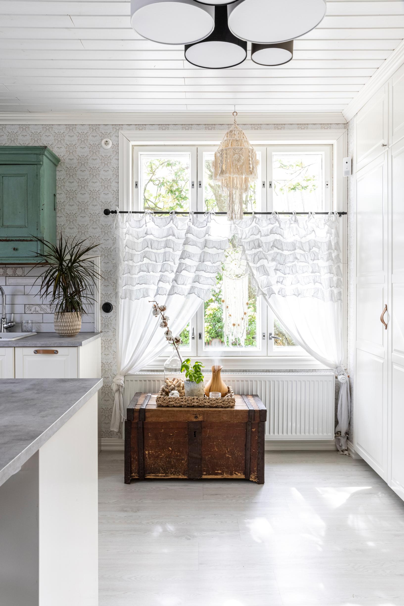 Lace curtains and an old wooden chest by the window