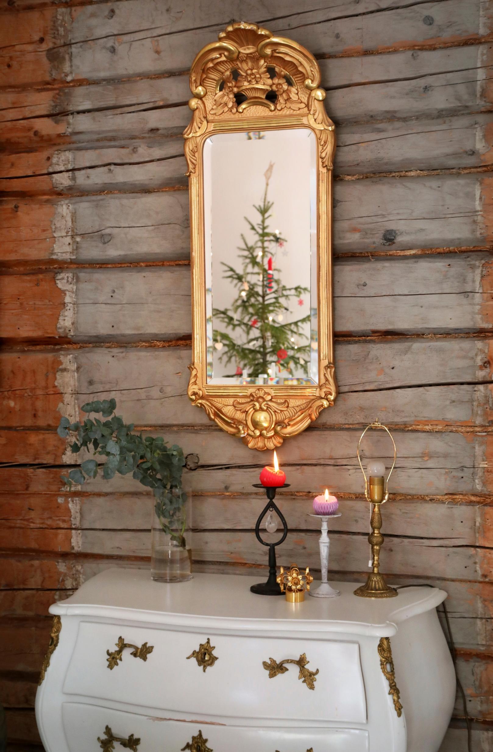 A decorative mirror and a chest of drawers