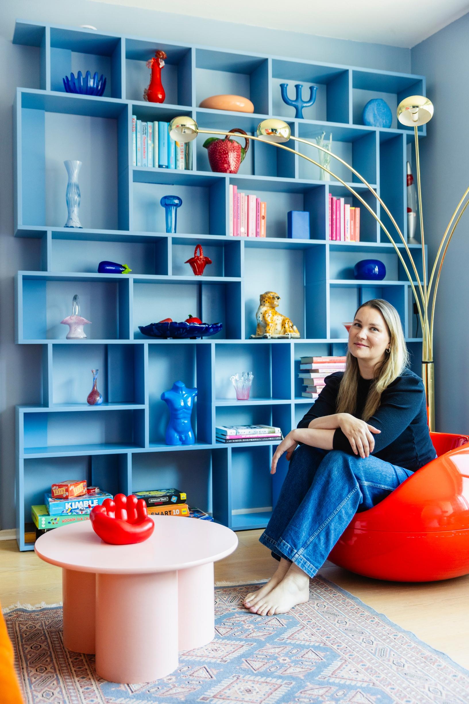 Irene Naakka in front of a blue bookshelf