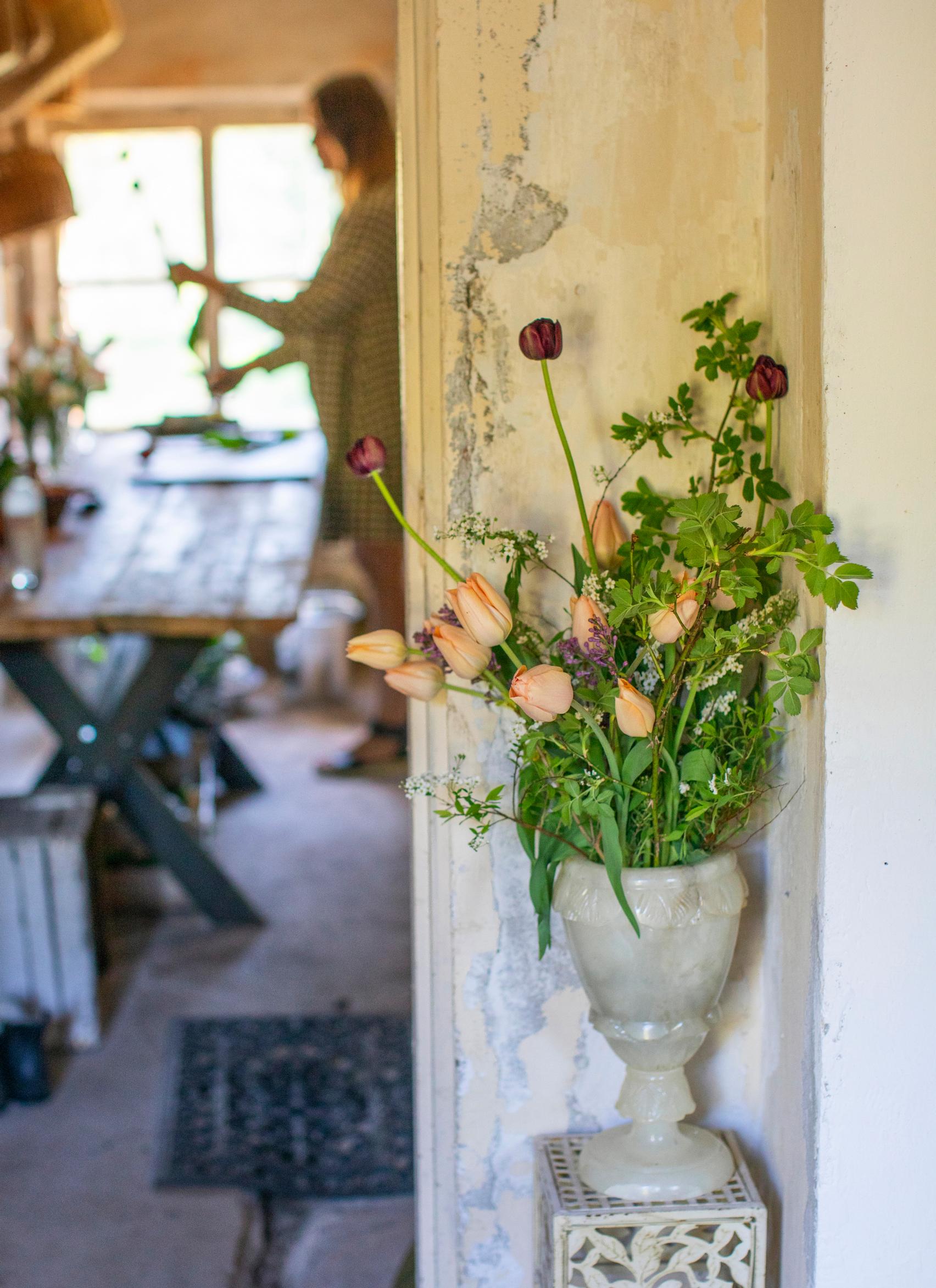 A vase with tulips, lilac, bridalwreath spirea and midsummer rose