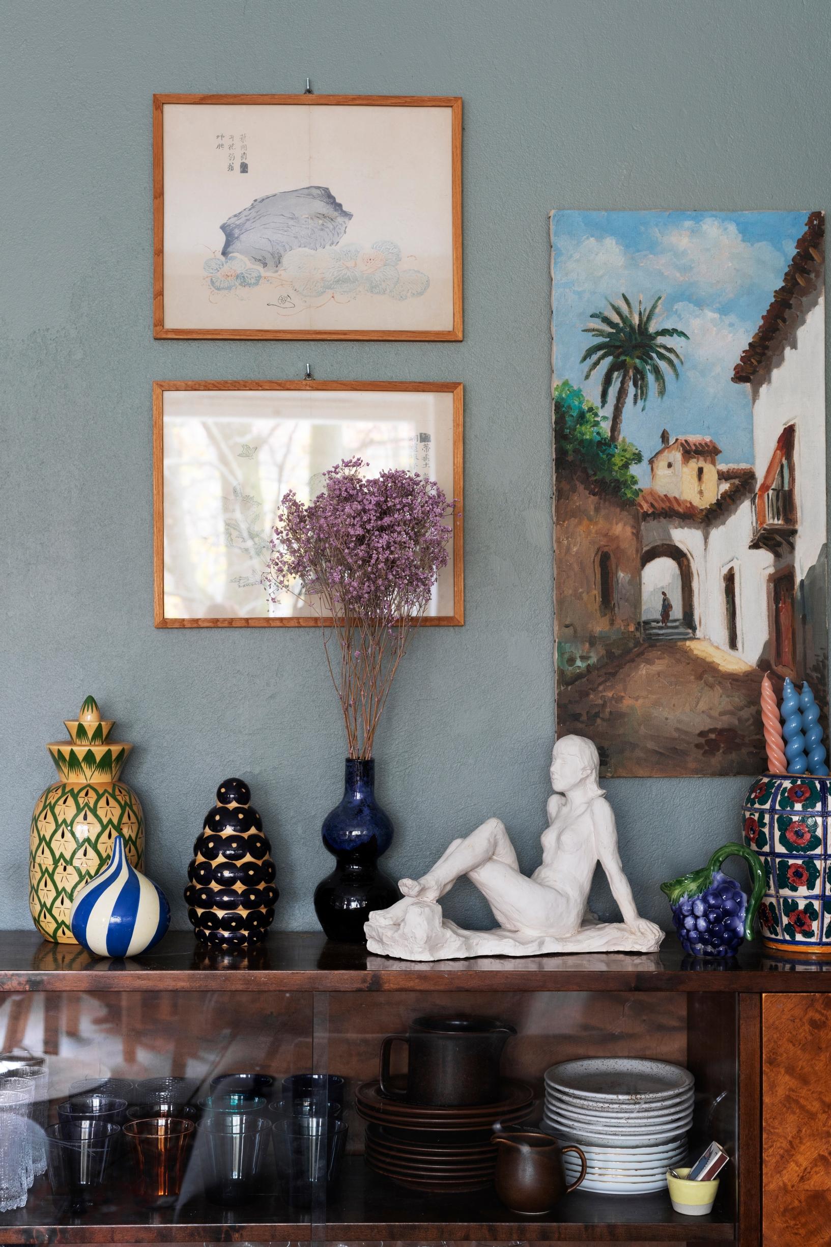 A display sideboard with old Arabia dishes and Iittala colored glass.
