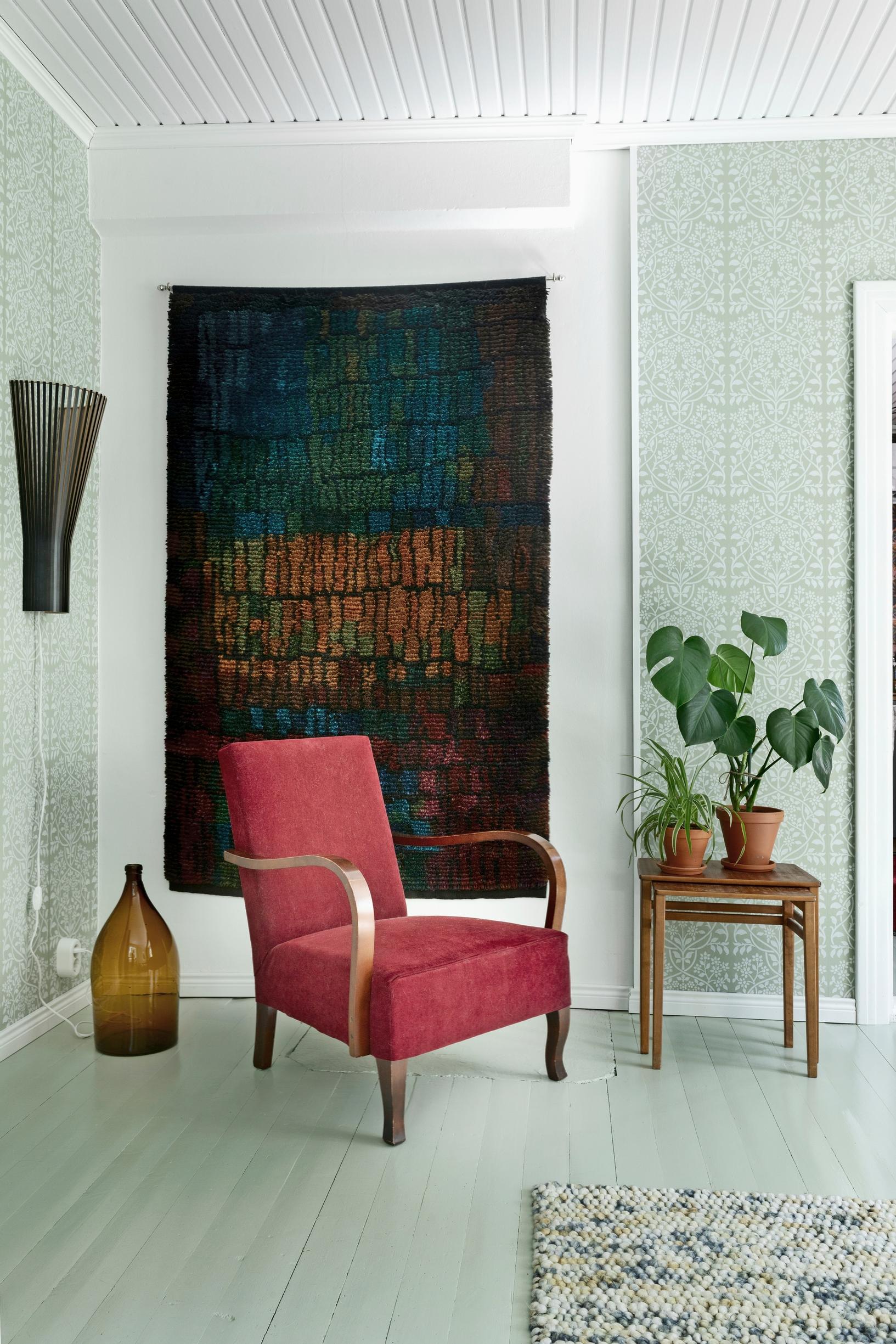 Ritva Puotila’s Maalla ja merellä rya rug and an armchair in the living room
