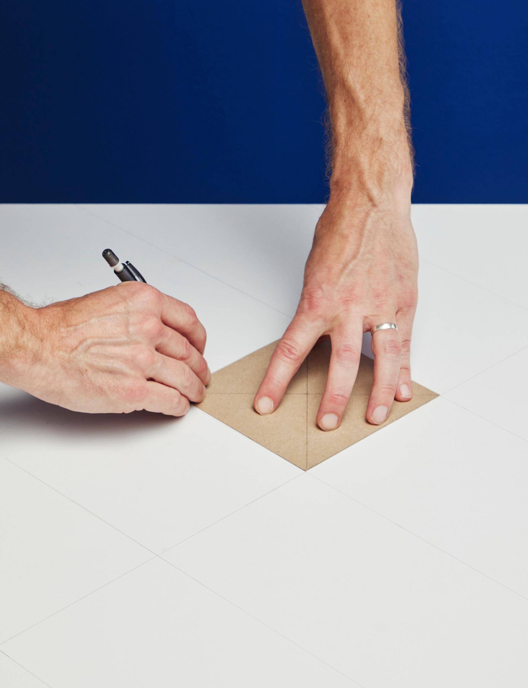 Draw a grid on your surface using a pencil and the cardboard template as a guide.