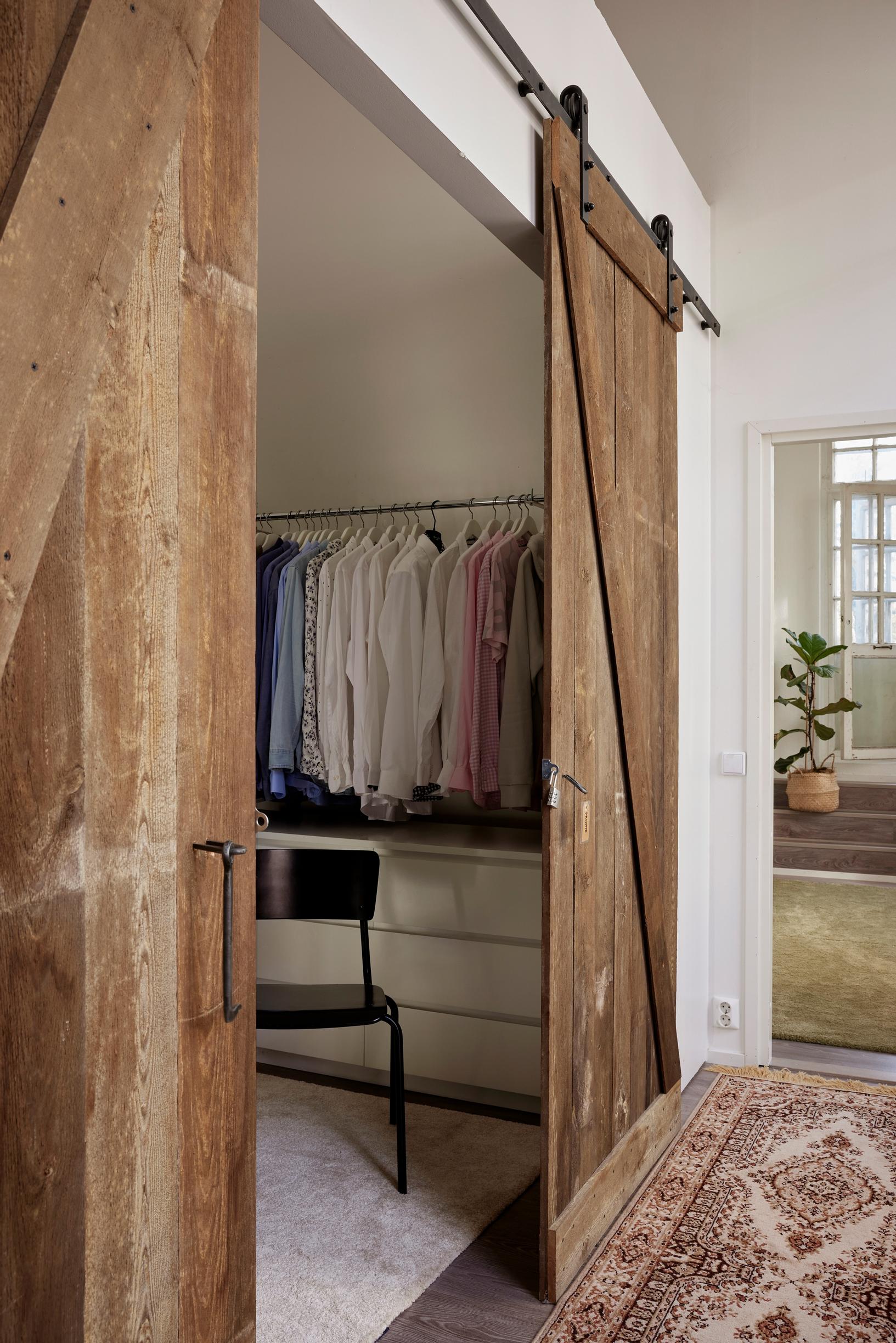 a walk-in closet separated by barn doors in the bedroom