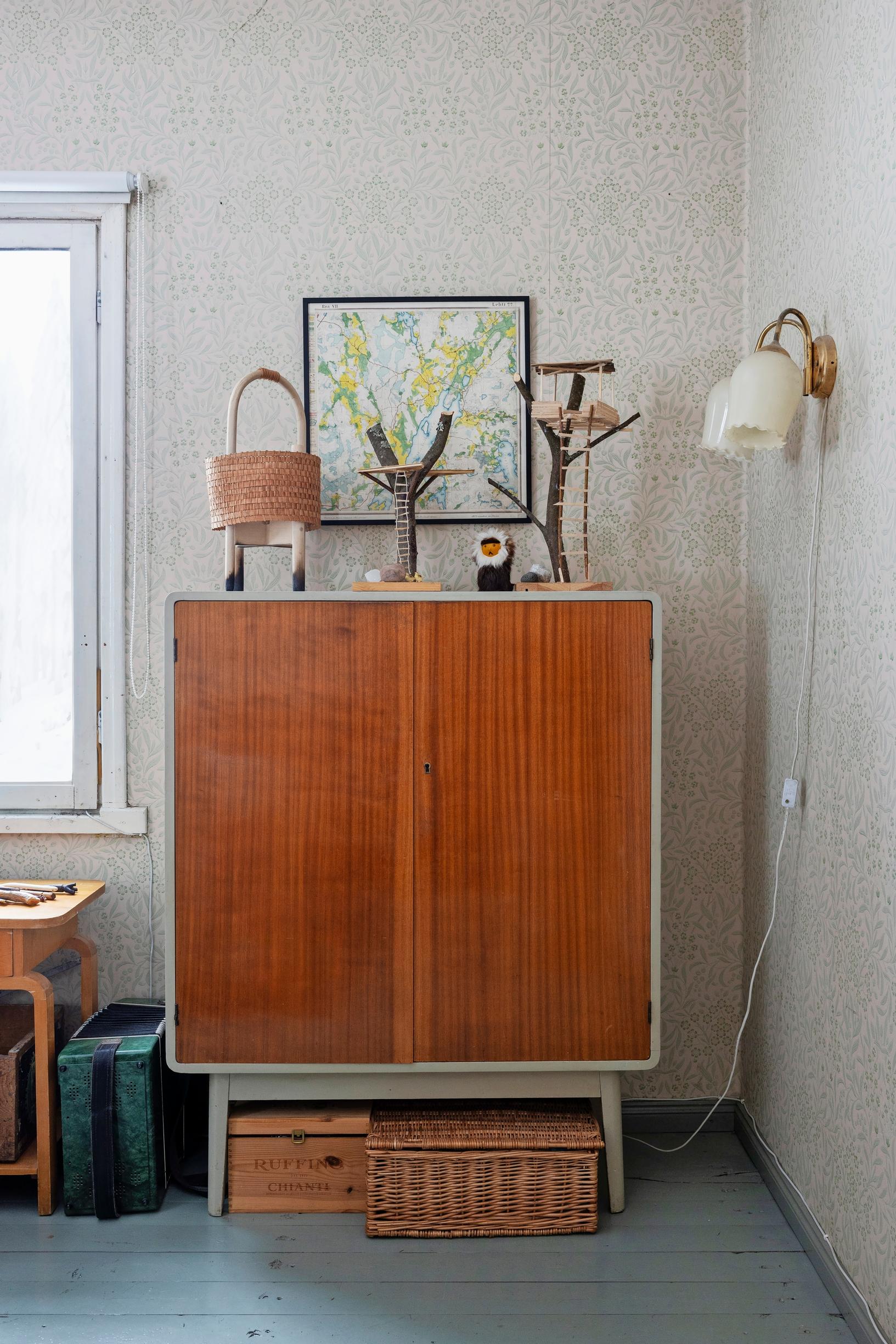 Craft projects on top of a brown linen closet, wall lamp