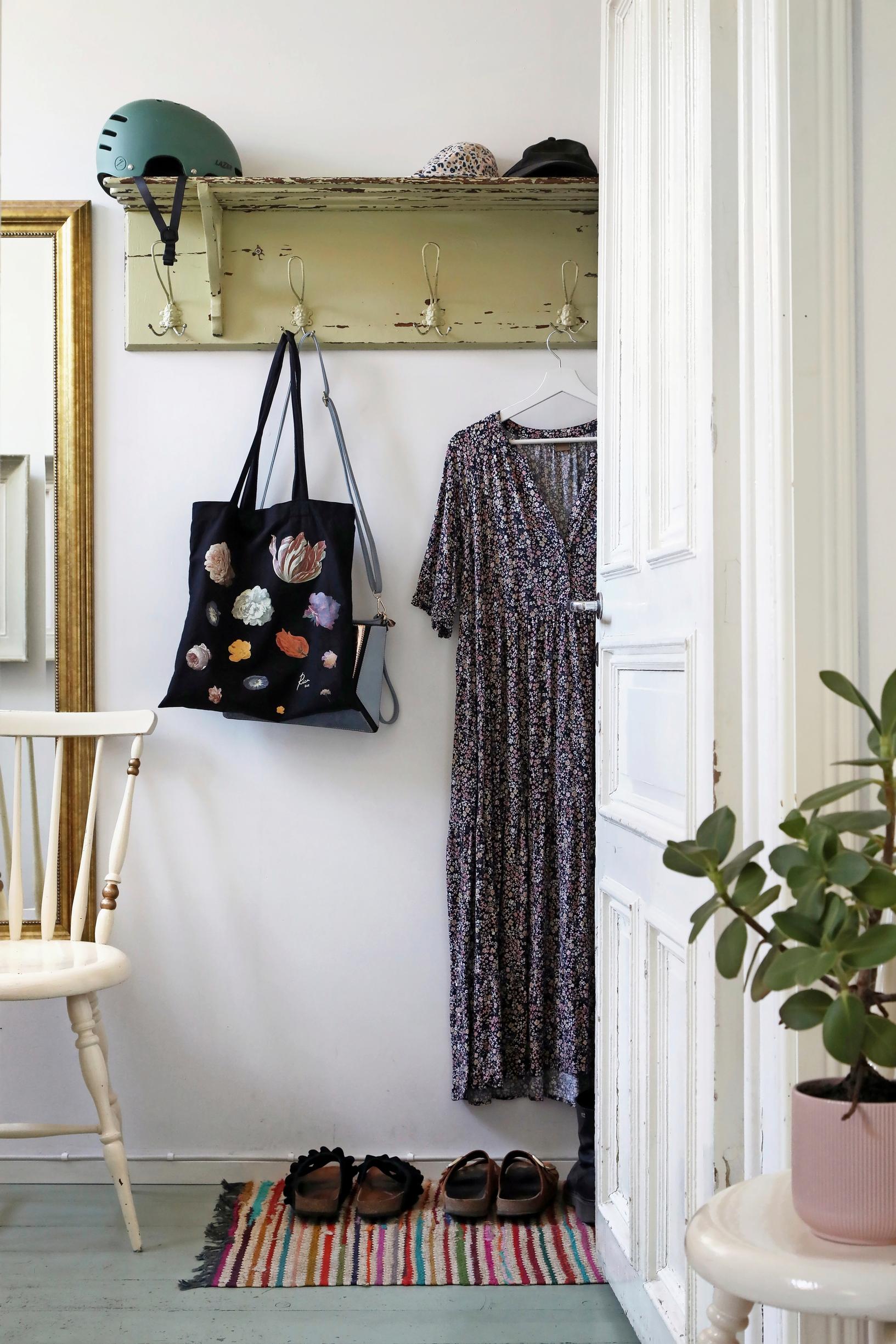 A photo of the entryway in a wooden home, featuring an old wooden coat rack.