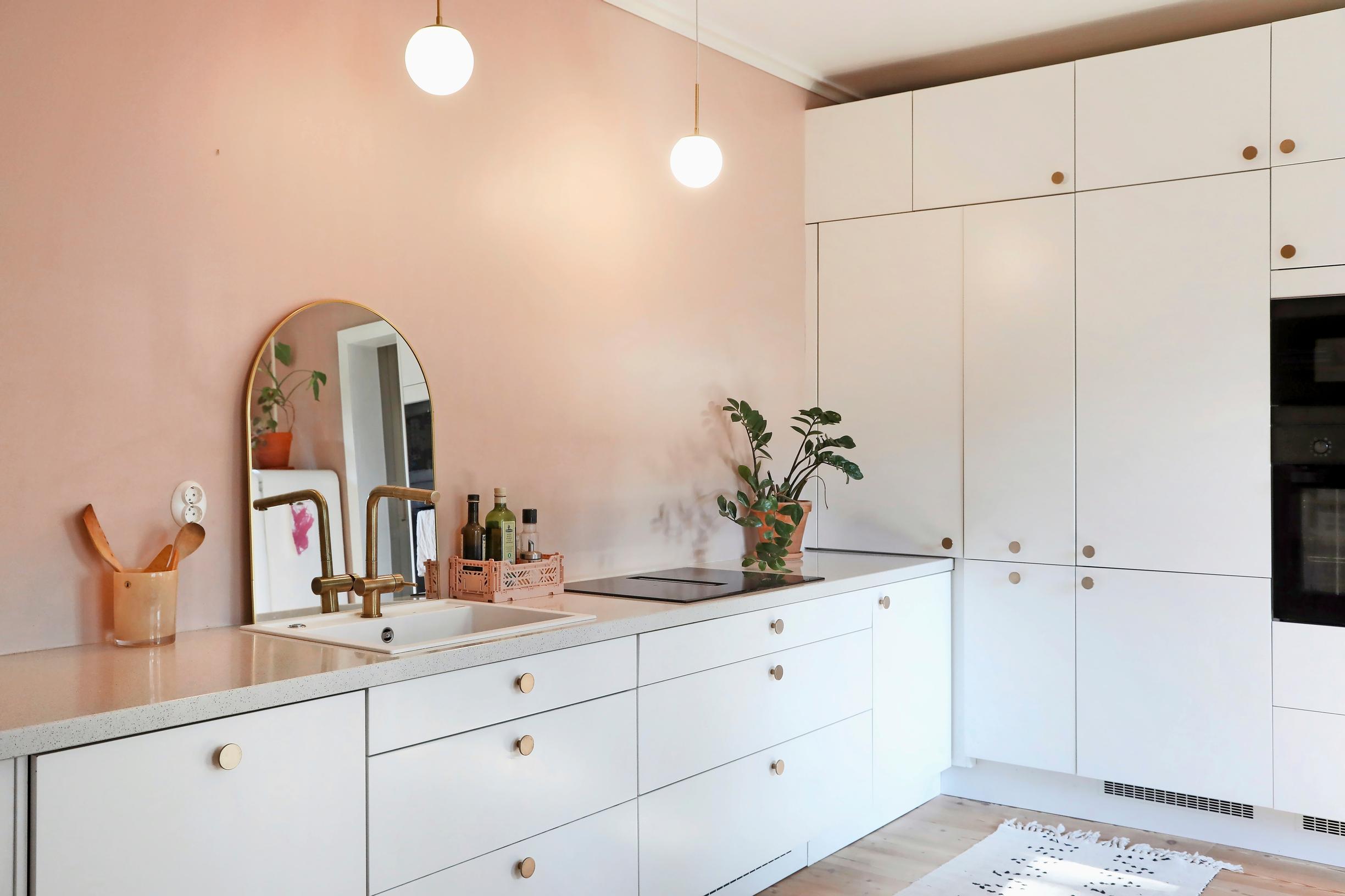 kitchen with a mirror and a pink wall