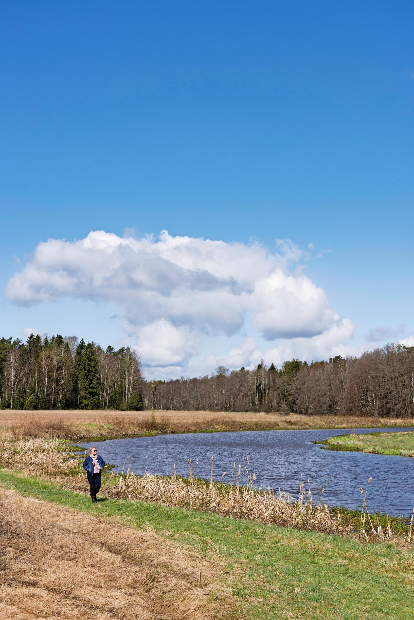 Author Anu Joenpolvi in her home yard by a river